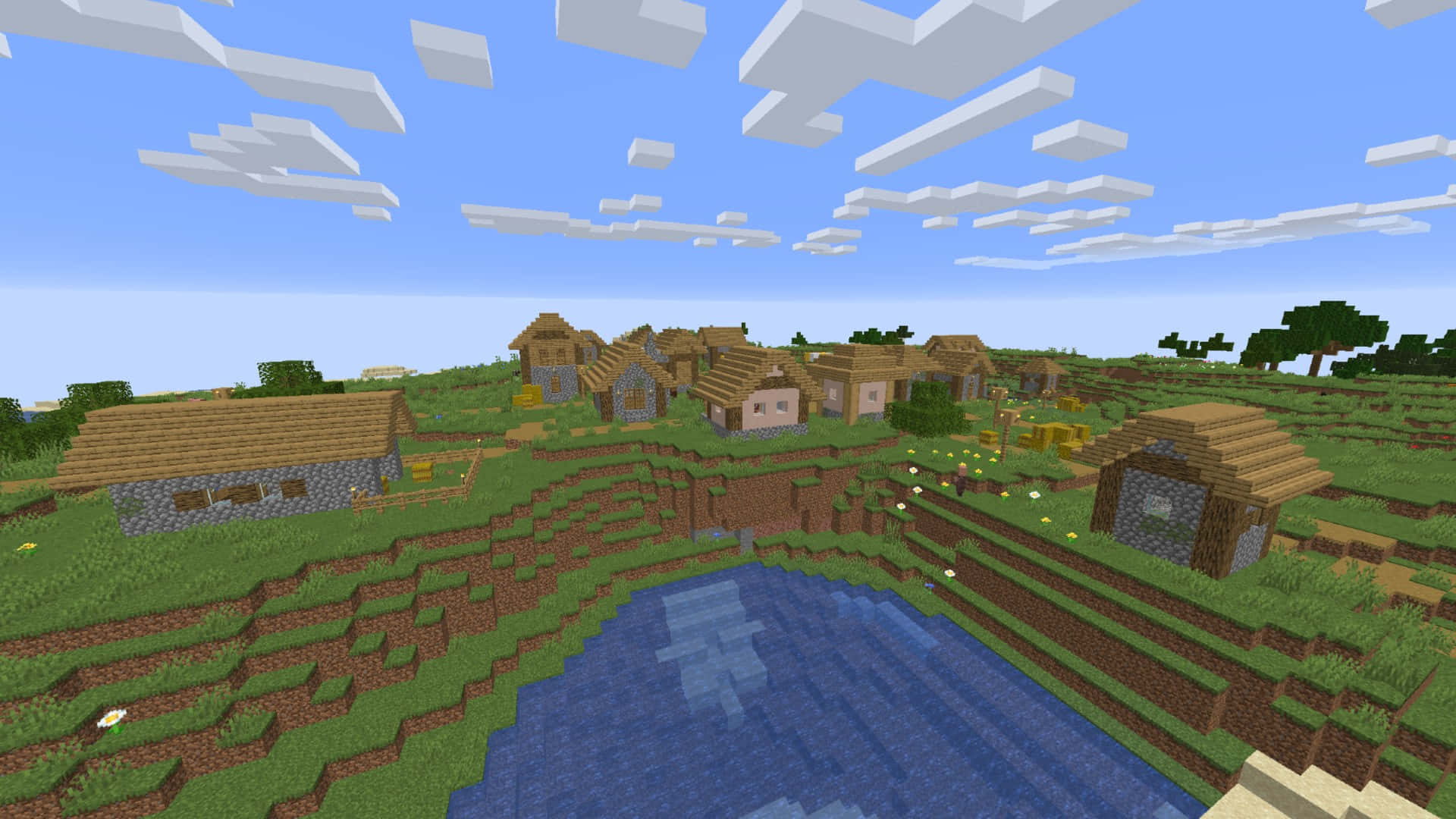 Lake 桌布 壁紙 — 一個像素化的Minecraft村莊，坐落在青草丘陵上，旁邊有一個藍色池塘，天空明亮，有方塊狀的雲。