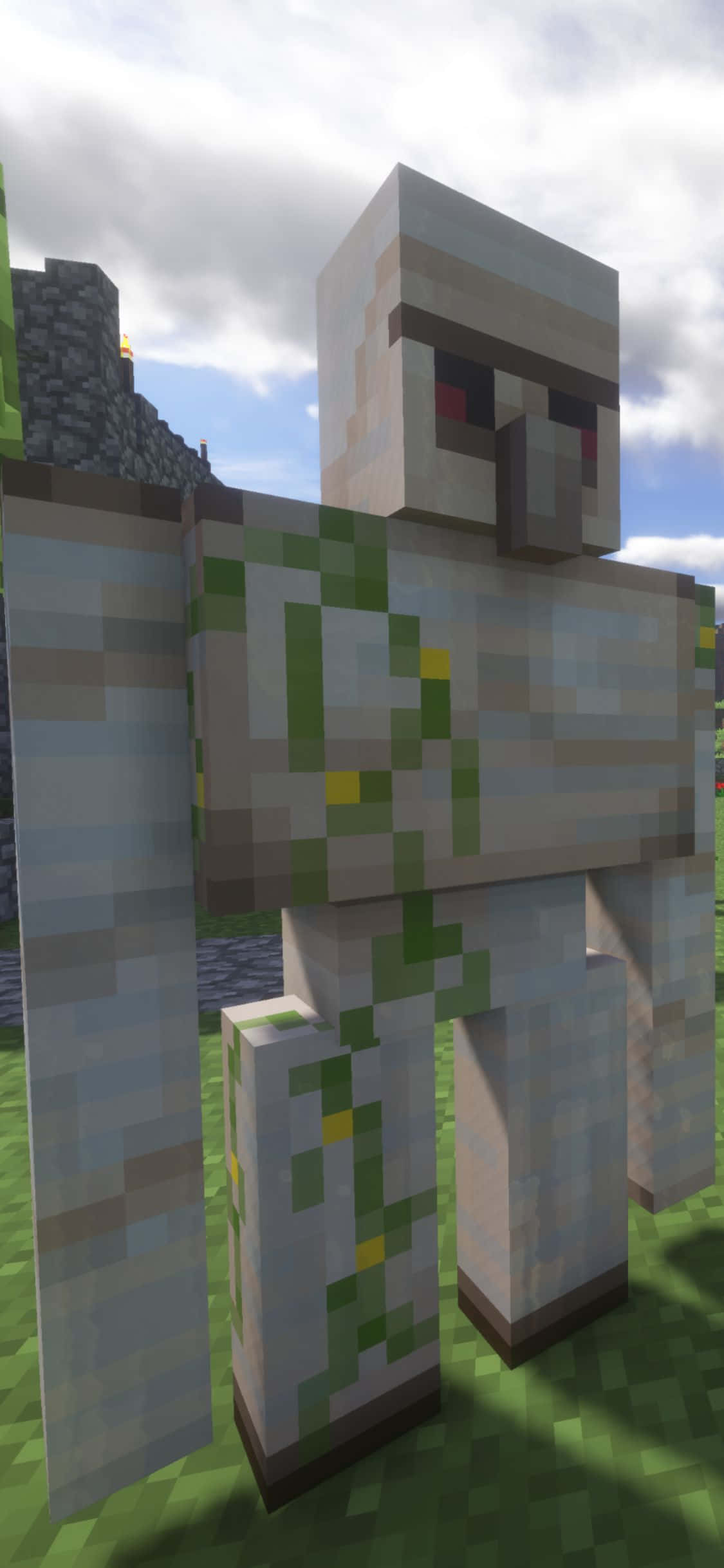 iPhone Xs Minecraft 桌布 壁紙 — 一個像素化的Minecraft殭屍站在草地上，天空多雲，背景有石頭建築。