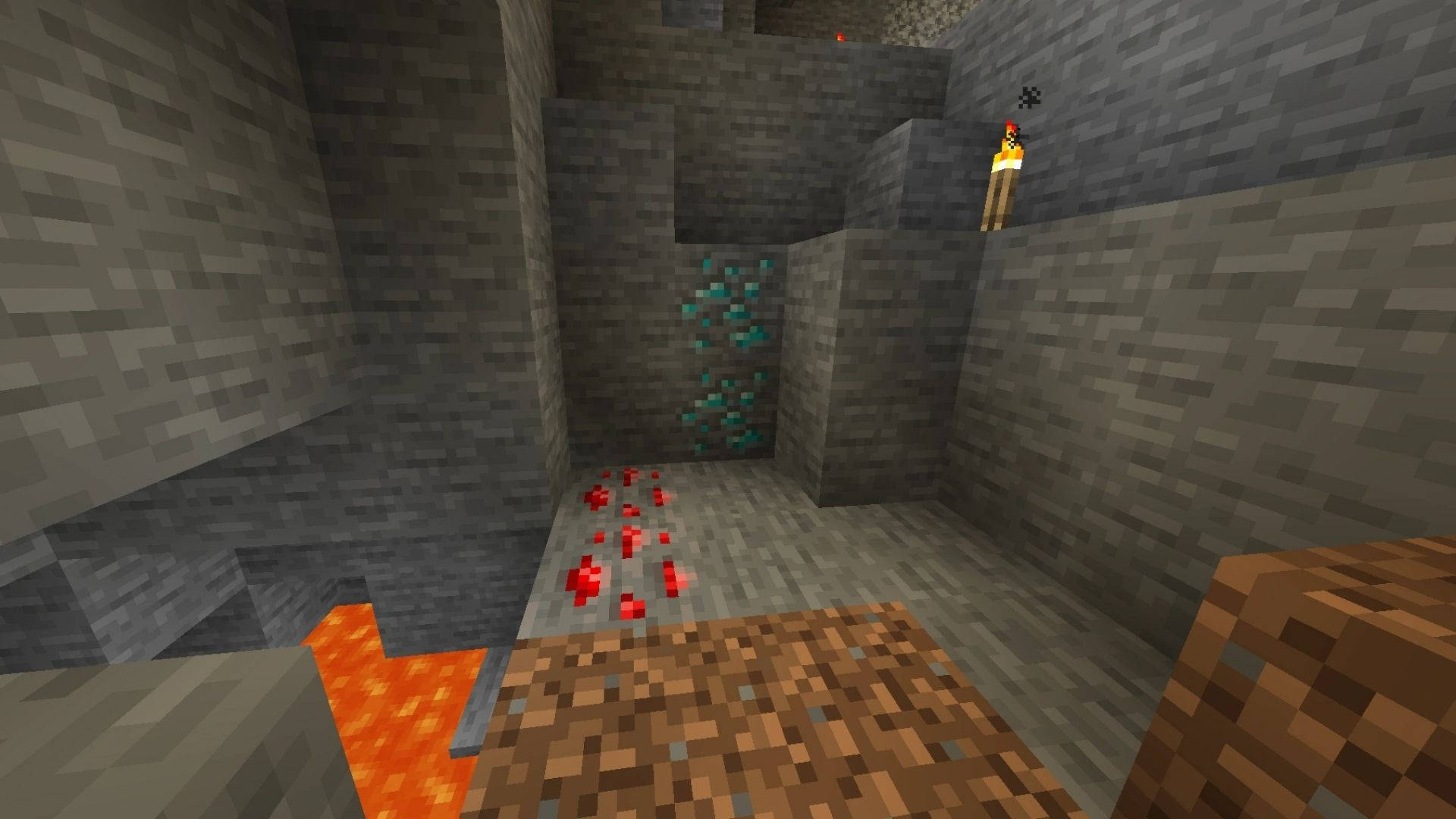 我的世界 鑽石 桌布 壁紙 — 一個像素化的Minecraft礦井，有流動的熔岩、紅石粉，以及一支火炬照亮石牆和鑽石礦。
