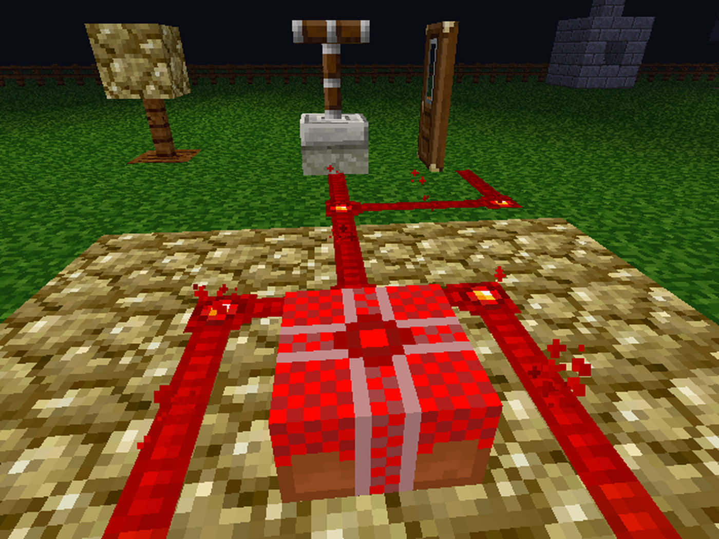 Minecraft Redstone 桌布 壁紙 — 一個像素化的Minecraft紅石裝置，中央有一個包裝好的禮物盒，周圍環繞著紅石粉和火炬。