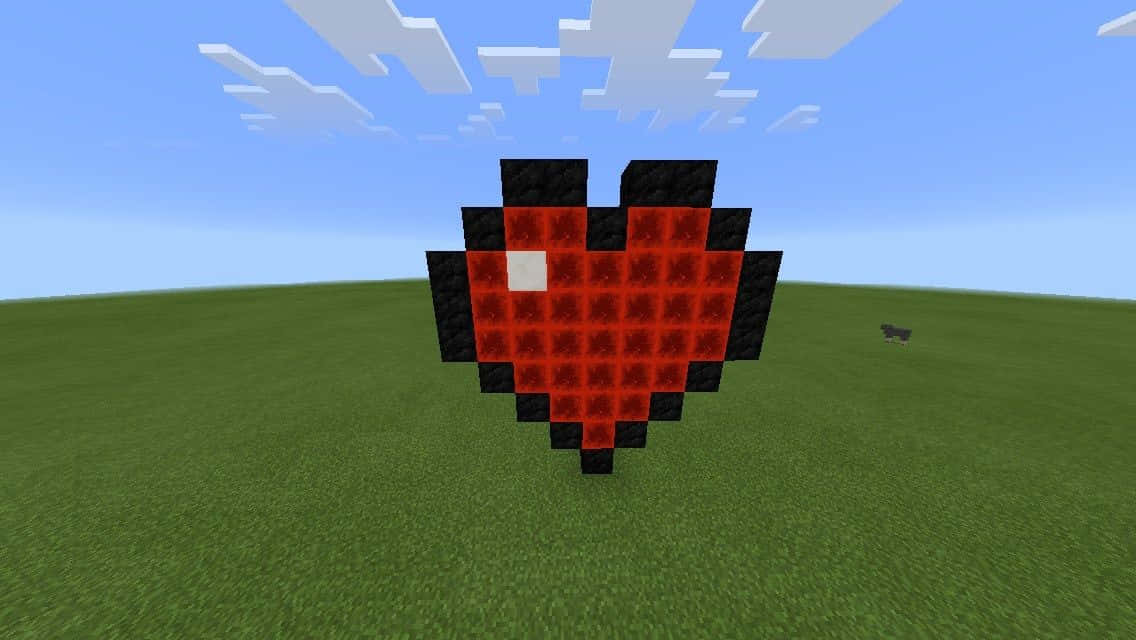 Minecraft Art 桌布 壁紙 — 一個像素化的紅色心形，帶有黑色輪廓和白色中心，放在有塊狀雲朵的藍天下的一片草地上。