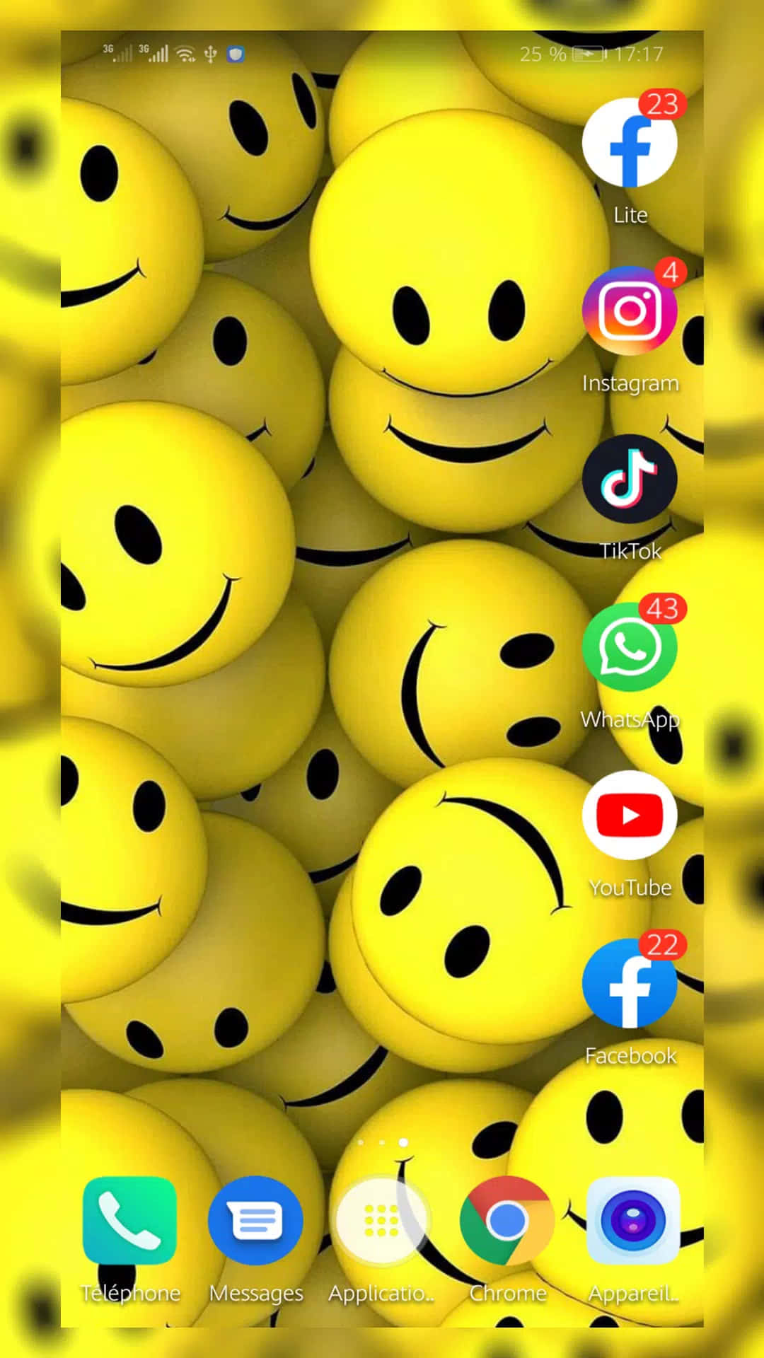 iPhone Emoji 桌布 壁紙 — 一個充滿亮黃色笑臉的電話螢幕作為桌布，上面覆蓋著應用程式圖示。