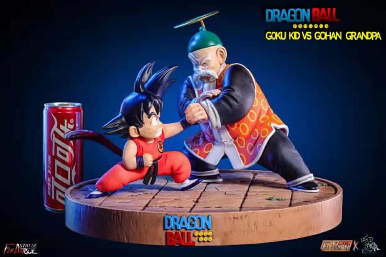 Grandpa Gohan 桌布 壁紙 — 一個充滿動感的七龍珠雕像，展示身穿紅色衣服的年輕悟空在木製平台上與白髮的爺爺悟飯戰鬥，旁邊有一罐可口可樂。