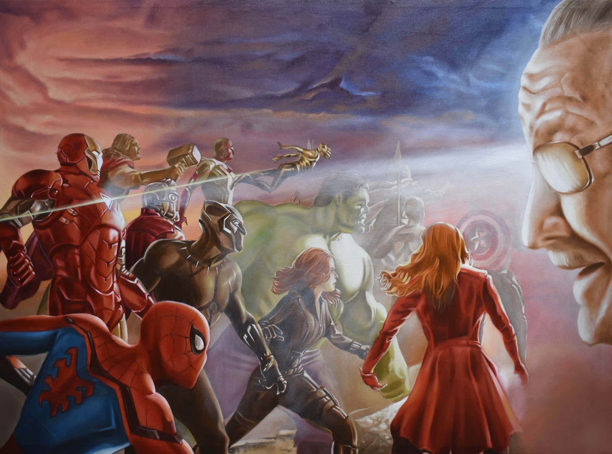 Stan Lee Tribute 桌布 壁紙 — 一個充滿動感的超級英雄團隊在戲劇性的暮色天空下向前衝，遠處有一個巨大的面孔若隱若現。