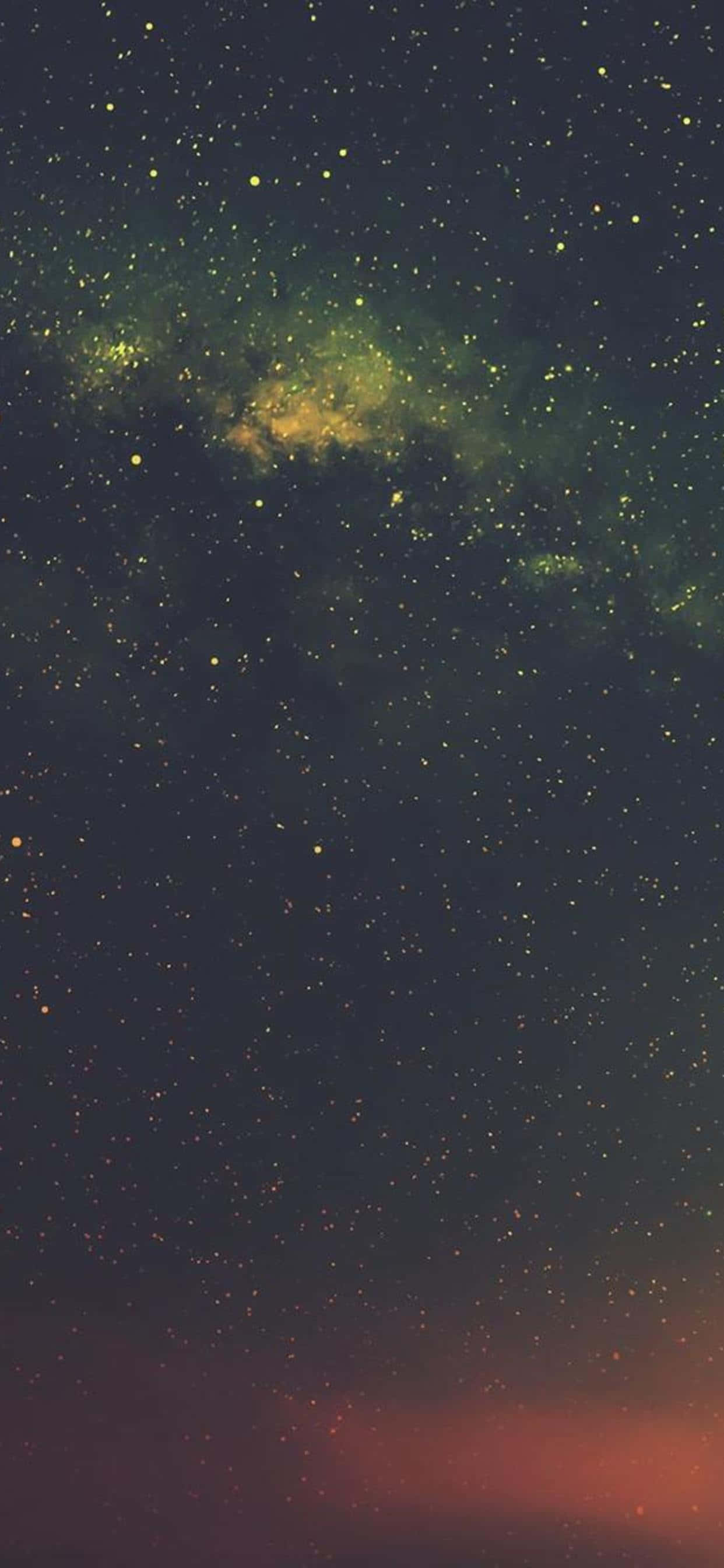 Dark Galaxy 桌布 壁紙 — 一個充滿星星和發光綠色星雲的宇宙夜空，在溫暖的橙色地平線之上。