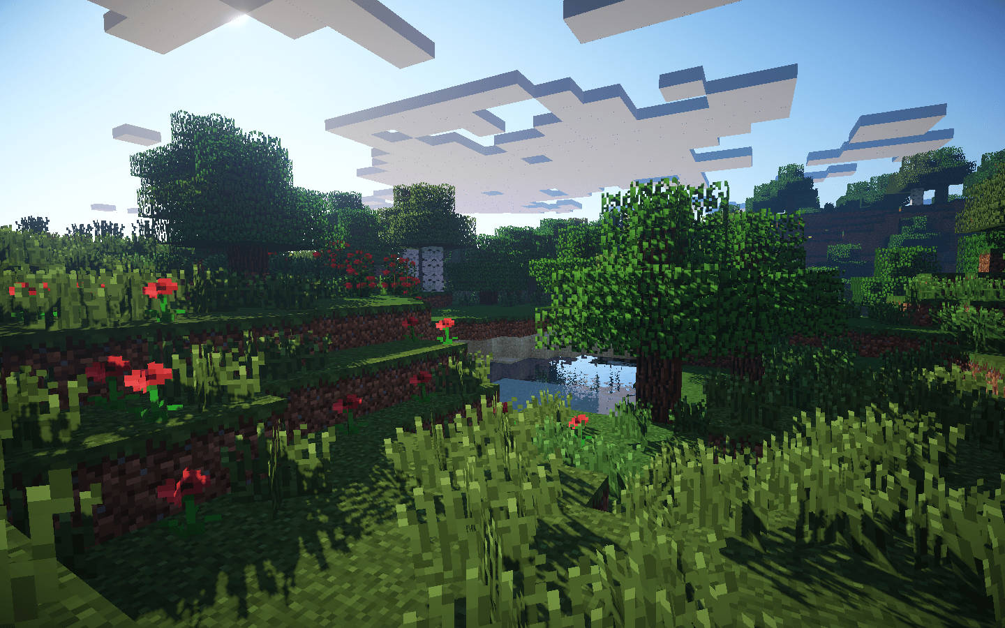 我的世界 高畫質壁紙 桌布 壁紙 — 一個充滿活力的Minecraft景觀，有像素化的樹木、花朵和一個池塘，上方是方塊狀的雲朵。