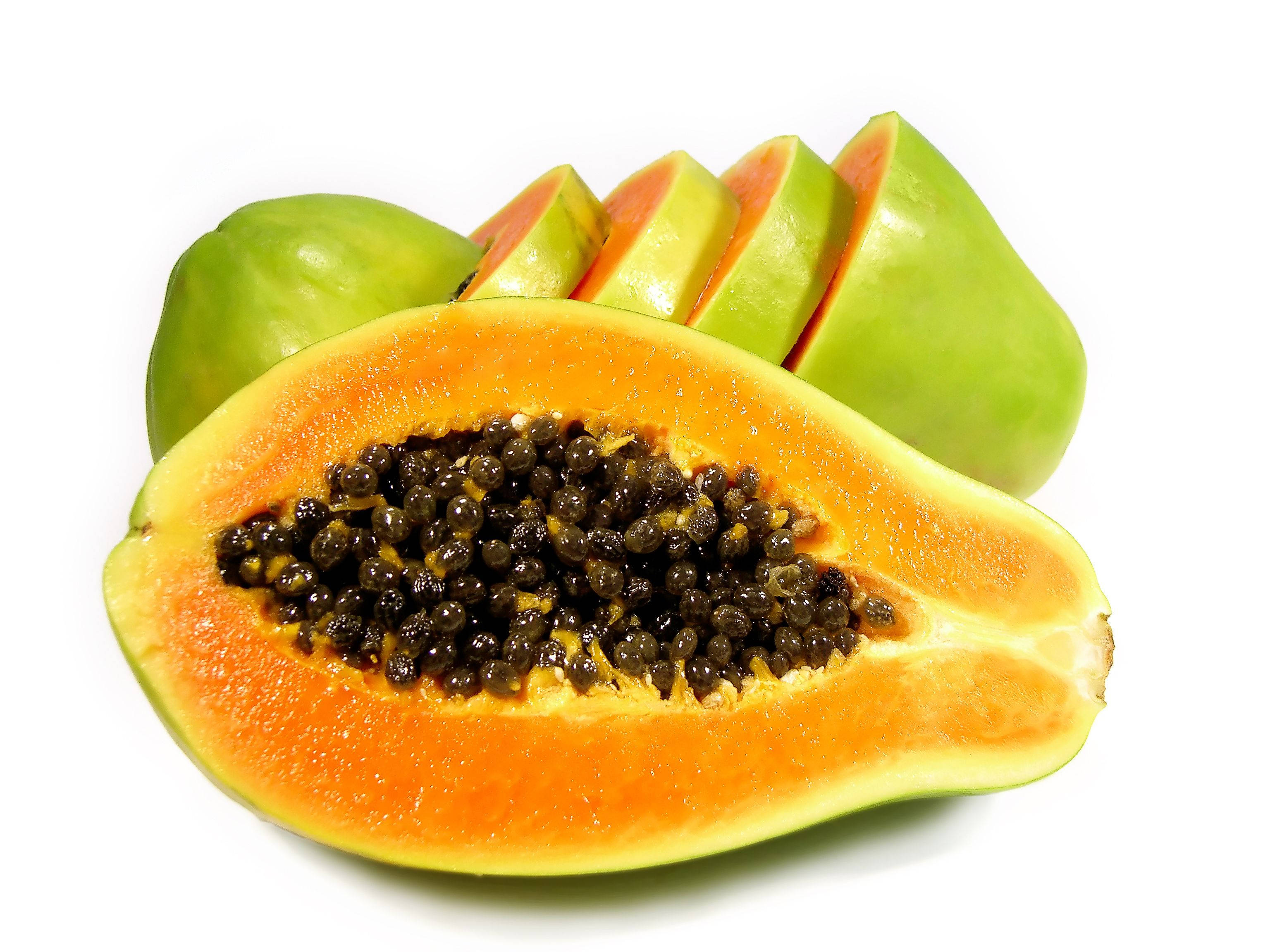 Fruits 桌布 壁紙 — 一個充滿活力的半切木瓜，帶有多汁的橙色果肉和黑色種子，旁邊放著完整和切片青木瓜，背景是乾淨的白色。
