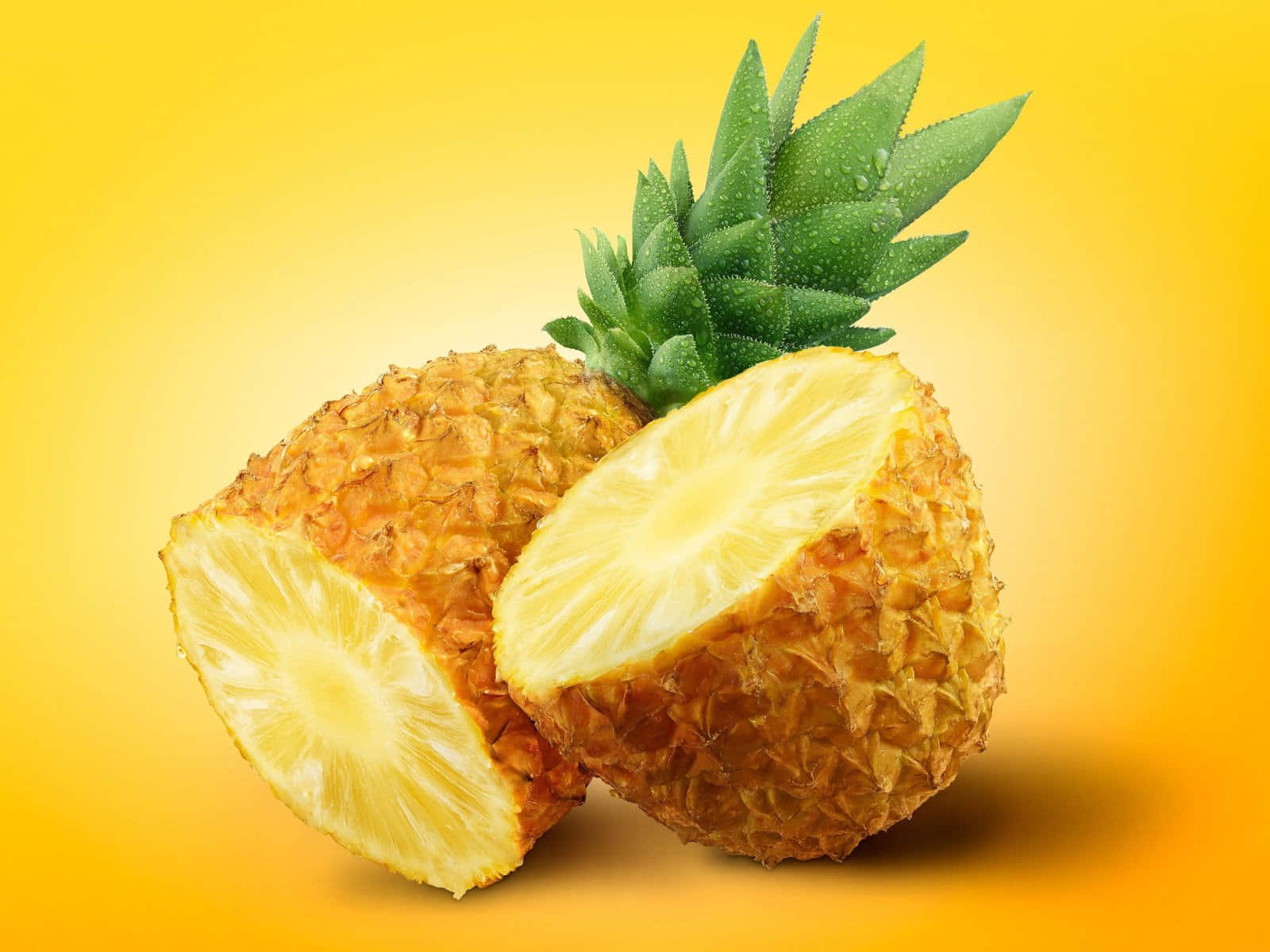 Pineapple Desktop 桌布 壁紙 — 一個充滿活力的半切鳳梨，多汁的黃色果肉和綠色冠部，置於溫暖的黃色漸層背景上。