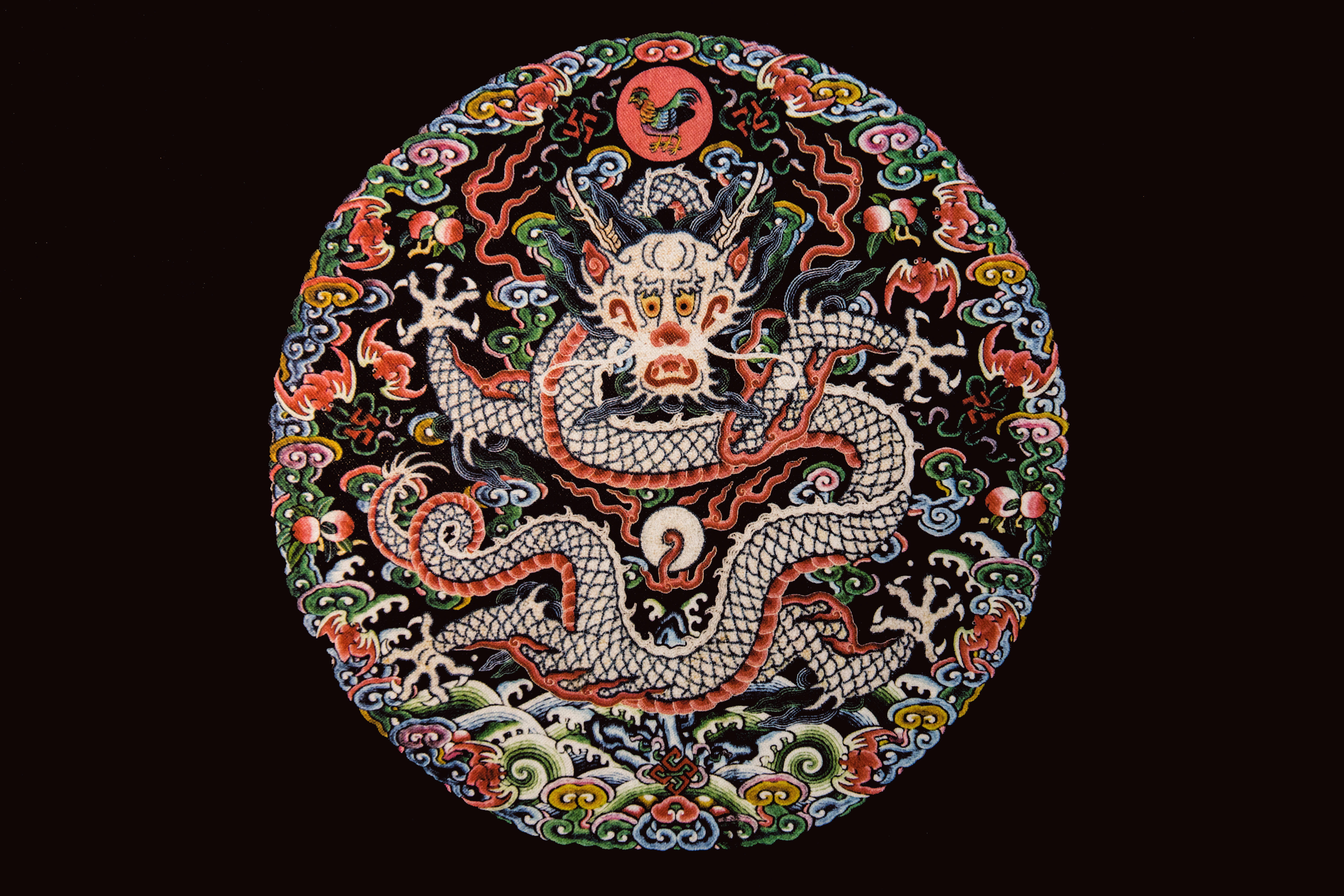 龍 桌布 壁紙 — 一個充滿活力的圓形刺繡，上面有一條細節豐富的白龍纏繞在色彩繽紛的漩渦圖案和神話生物之間，背景為深色。