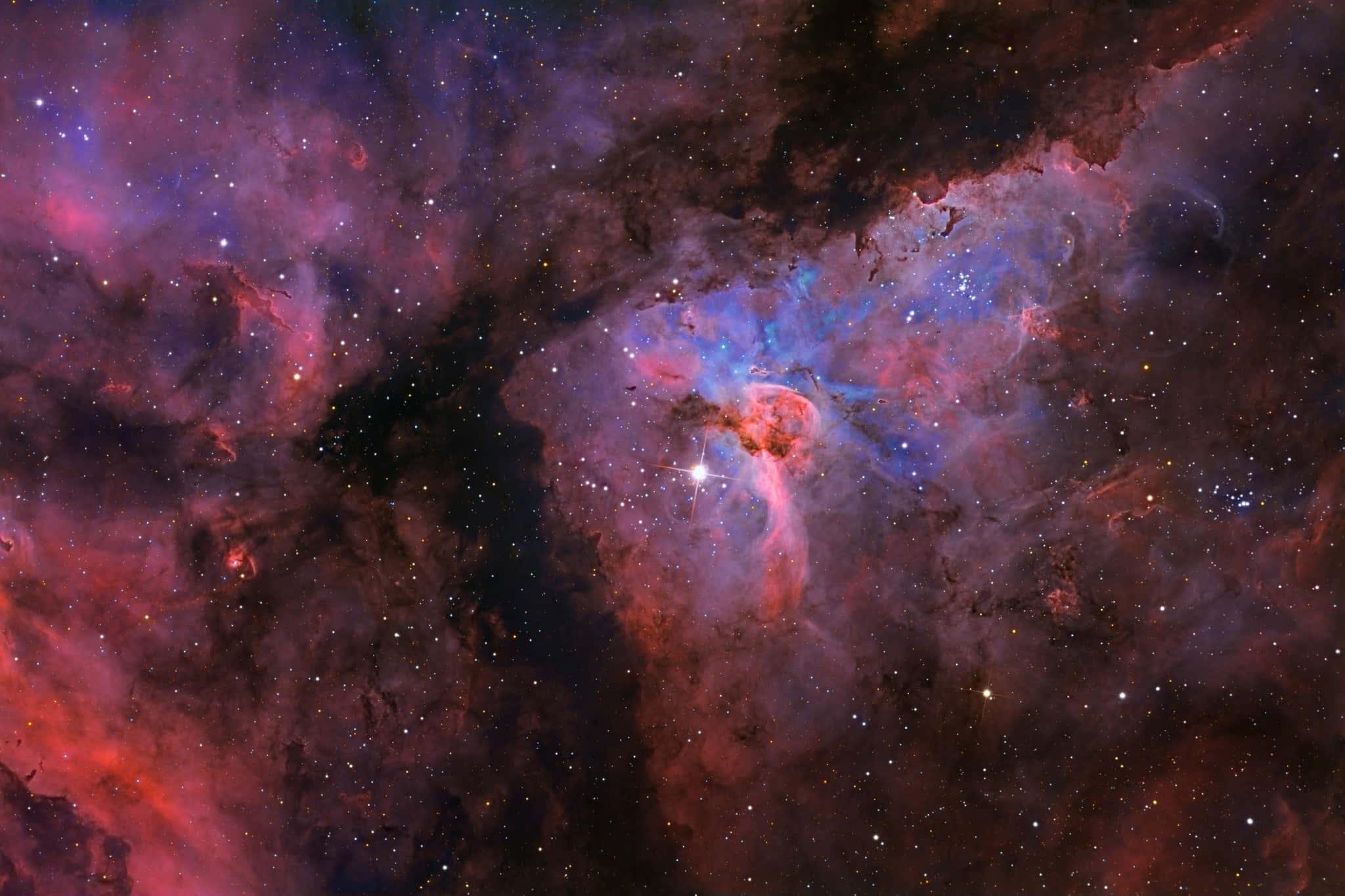 Carina Nebula 桌布 壁紙 — 一個充滿活力的宇宙星雲，在佈滿星辰的虛空中，翻騰著火紅與電光藍的色彩。