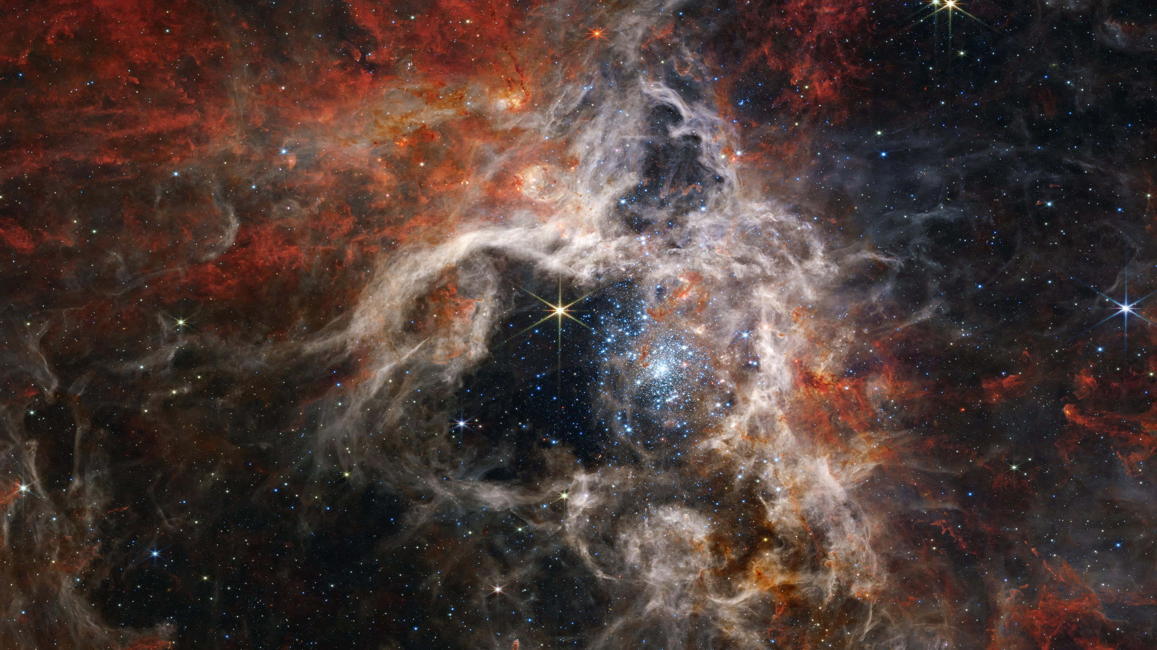 Telescope 桌布 壁紙 — 一個充滿活力的宇宙星雲，在佈滿星星的黑色虛空中，以火紅和發光的藍色旋轉。