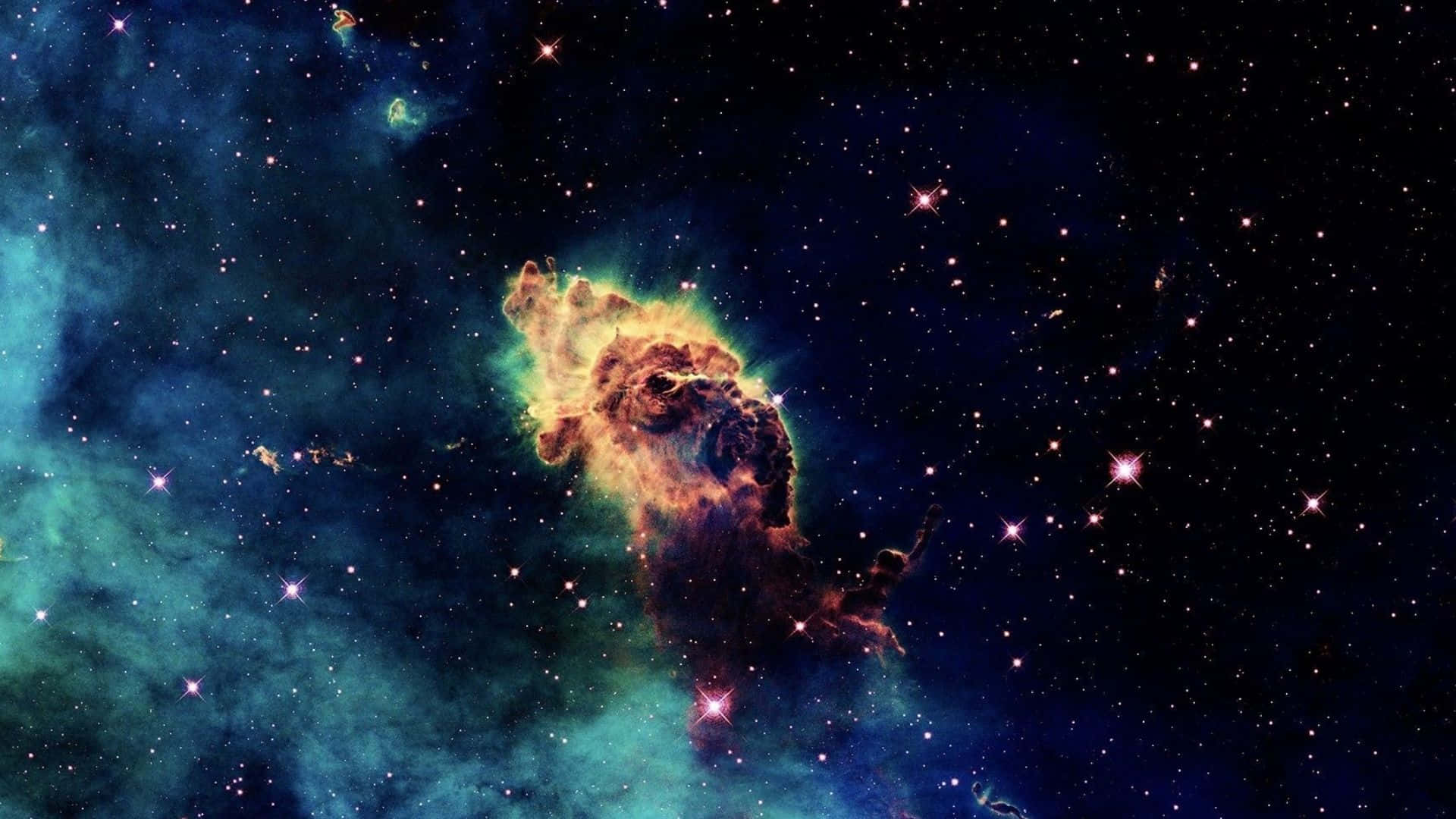 全高清 桌布 壁紙 — 一個充滿活力的宇宙星雲，在佈滿星辰的黑暗太空背景下，散發著火橙色和藍綠色的光芒。