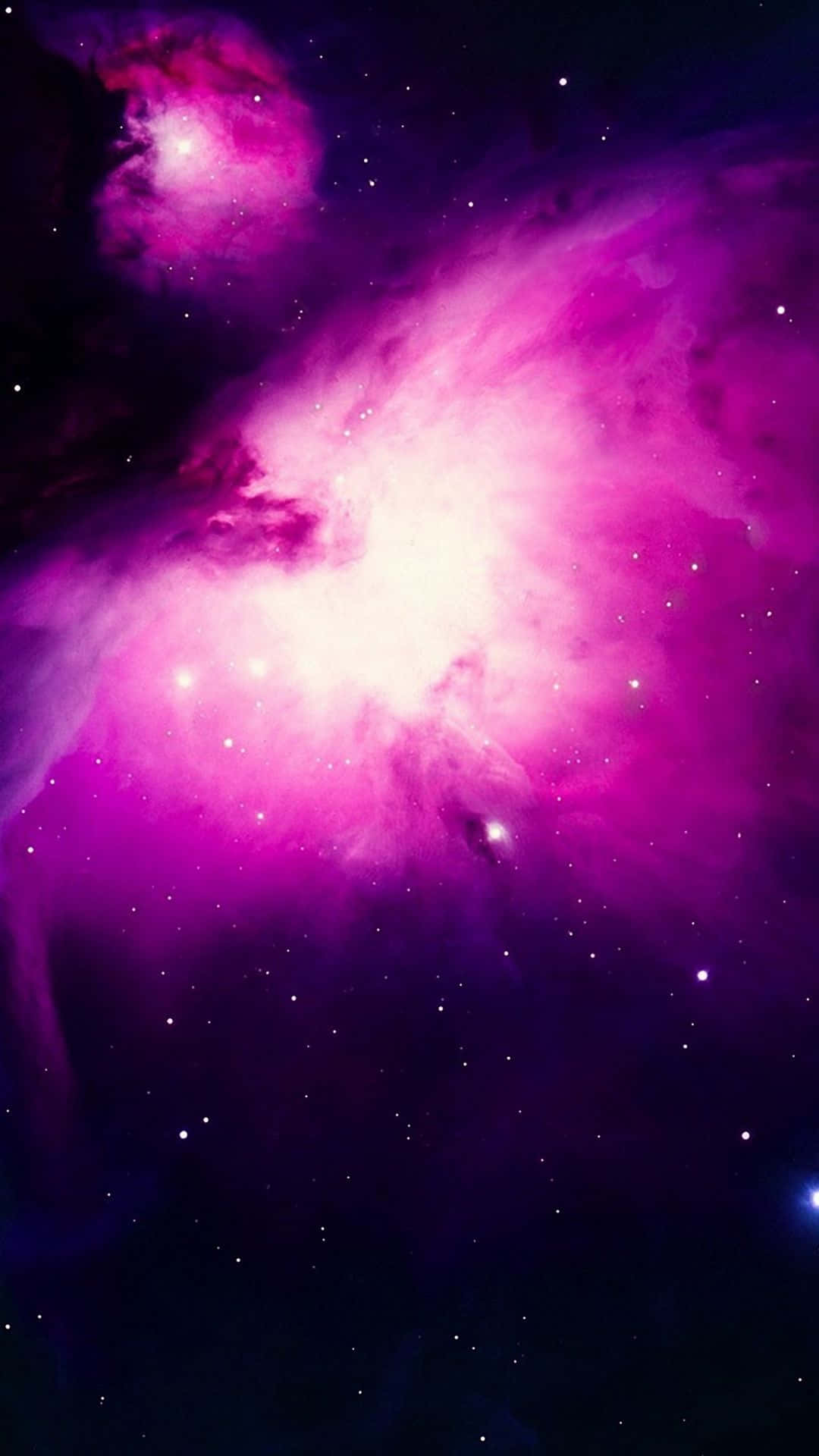 粉紅銀河 桌布 壁紙 — 一個充滿活力的宇宙星雲，在佈滿星辰的黑暗虛空中散發著耀眼的粉紅色和紫色色調。