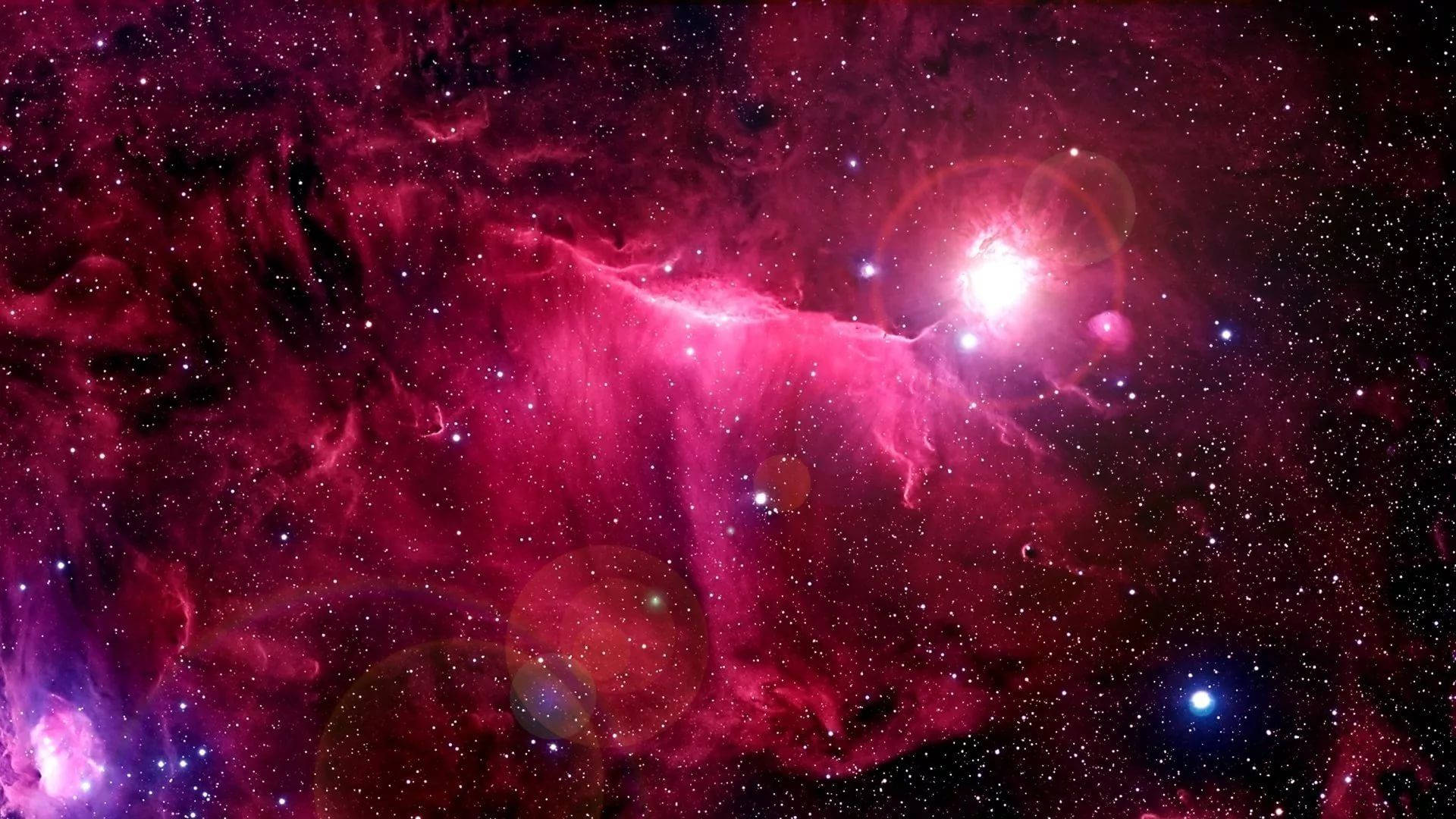 粉紅閃光 桌布 壁紙 — 一個充滿活力的宇宙星雲，在星場和鏡頭光暈的襯托下，散發出電光粉紅和紫色的色調。