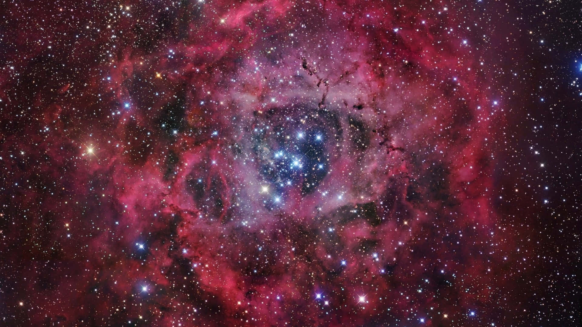 銀河 桌布 壁紙 — 一個充滿活力的宇宙星雲，在星場背景下，圍繞著一簇明亮的藍色星星旋轉著粉紅色和紫色的氣體。