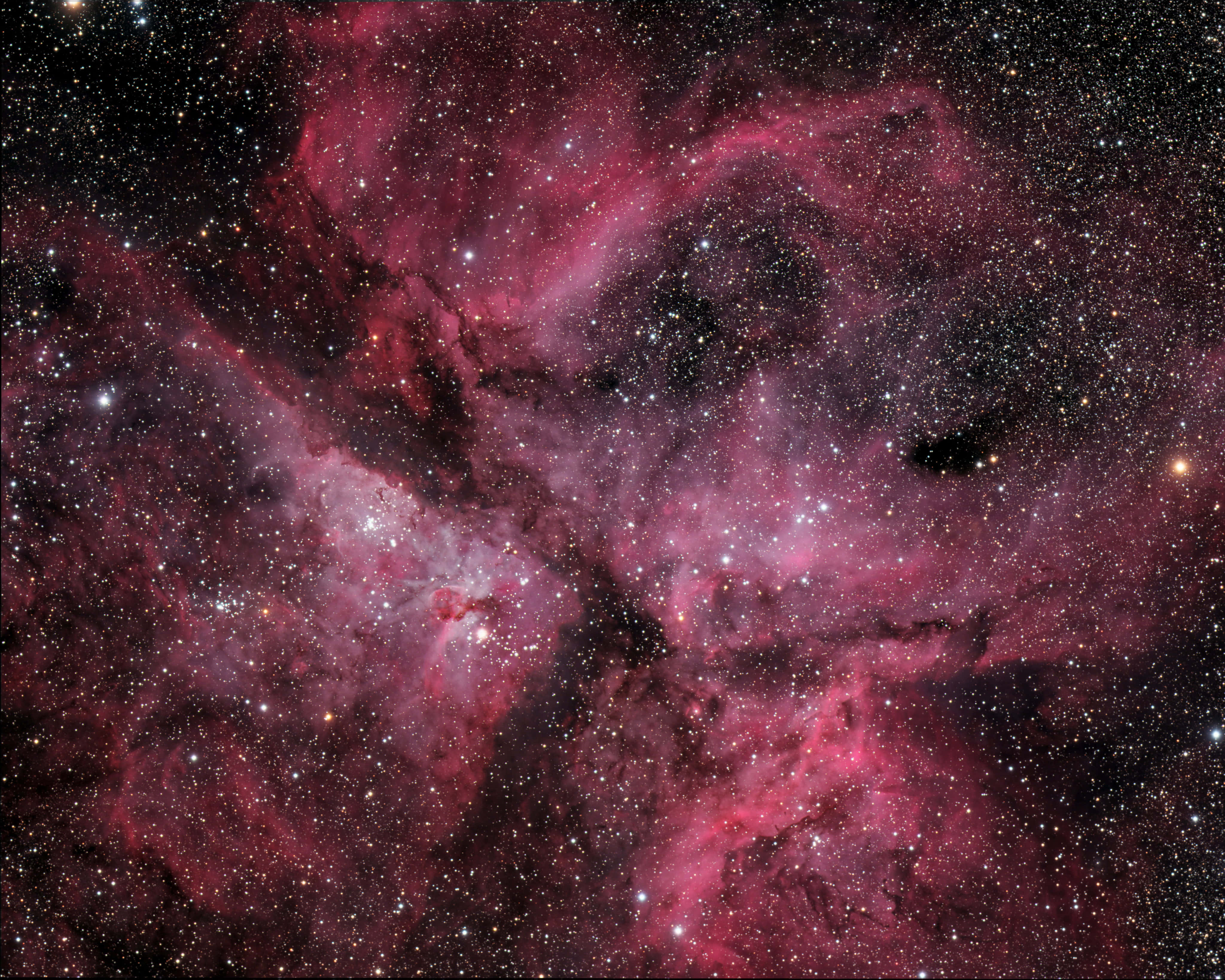 桌布 壁紙 — 一個充滿活力的宇宙星雲，在星空背景下旋轉著深洋紅色和深紅色的雲層。