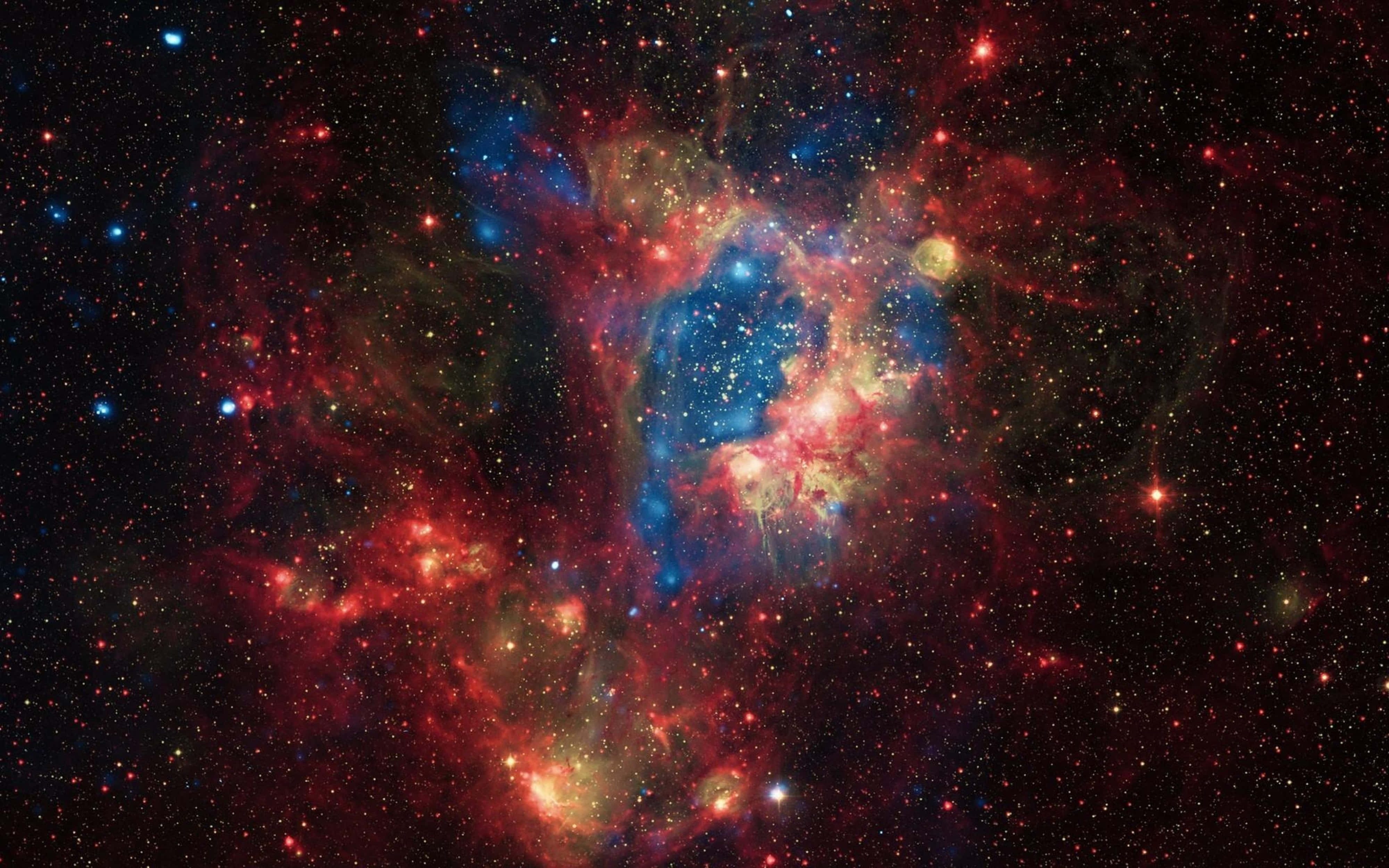 高清 桌布 壁紙 — 一個充滿活力的宇宙星雲，在星空背景下旋轉著紅色、藍色和金色的氣體。