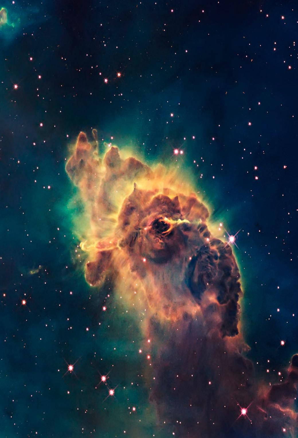 雲朵 桌布 壁紙 — 一個充滿活力的宇宙星雲，在深空的星場背景下散發出火橙色和藍綠色的光芒。