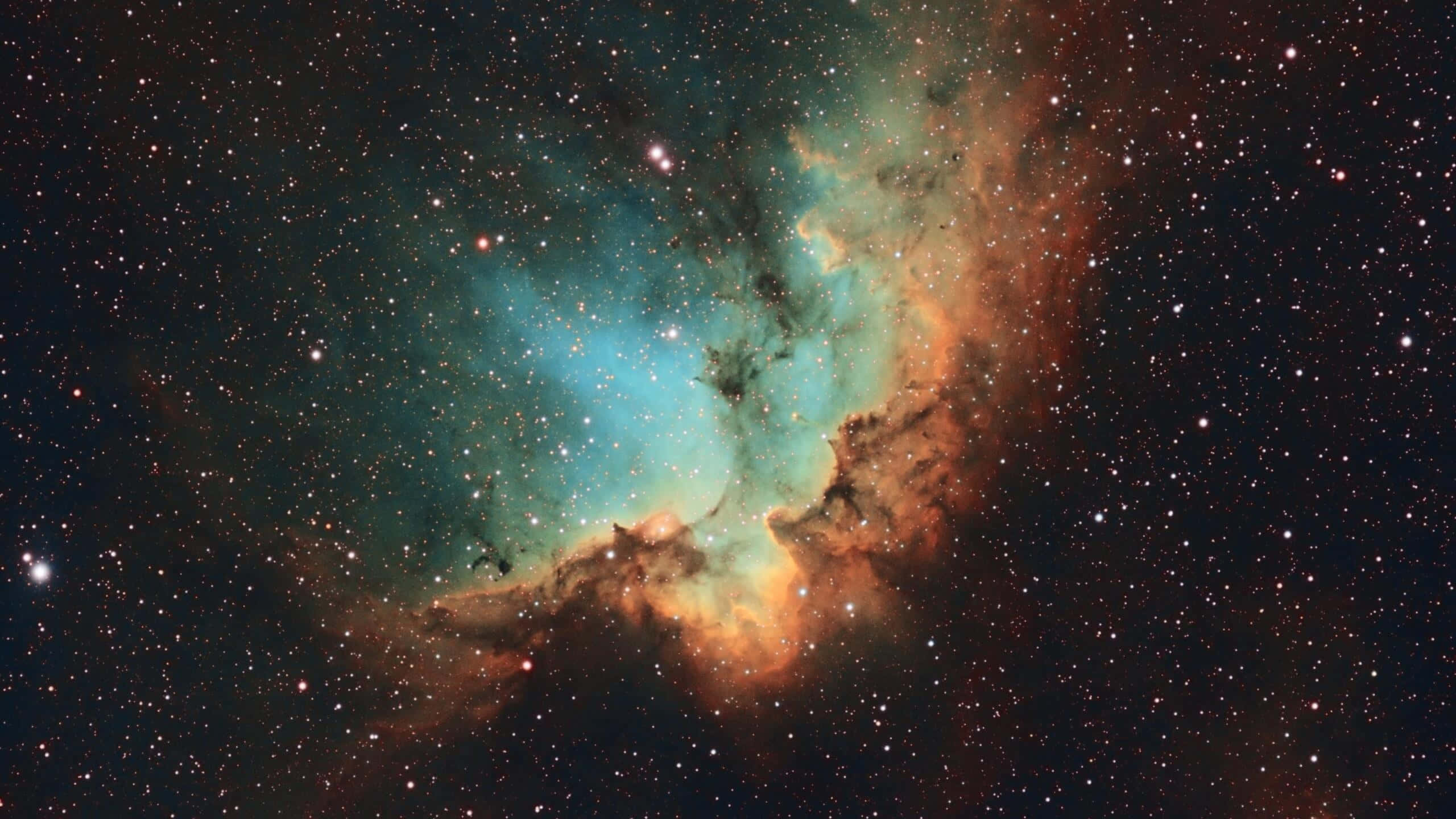 1440p Space 桌布 壁紙 — 一個充滿活力的宇宙星雲，在深空的星場中旋轉著青綠色和橙色的氣體雲。