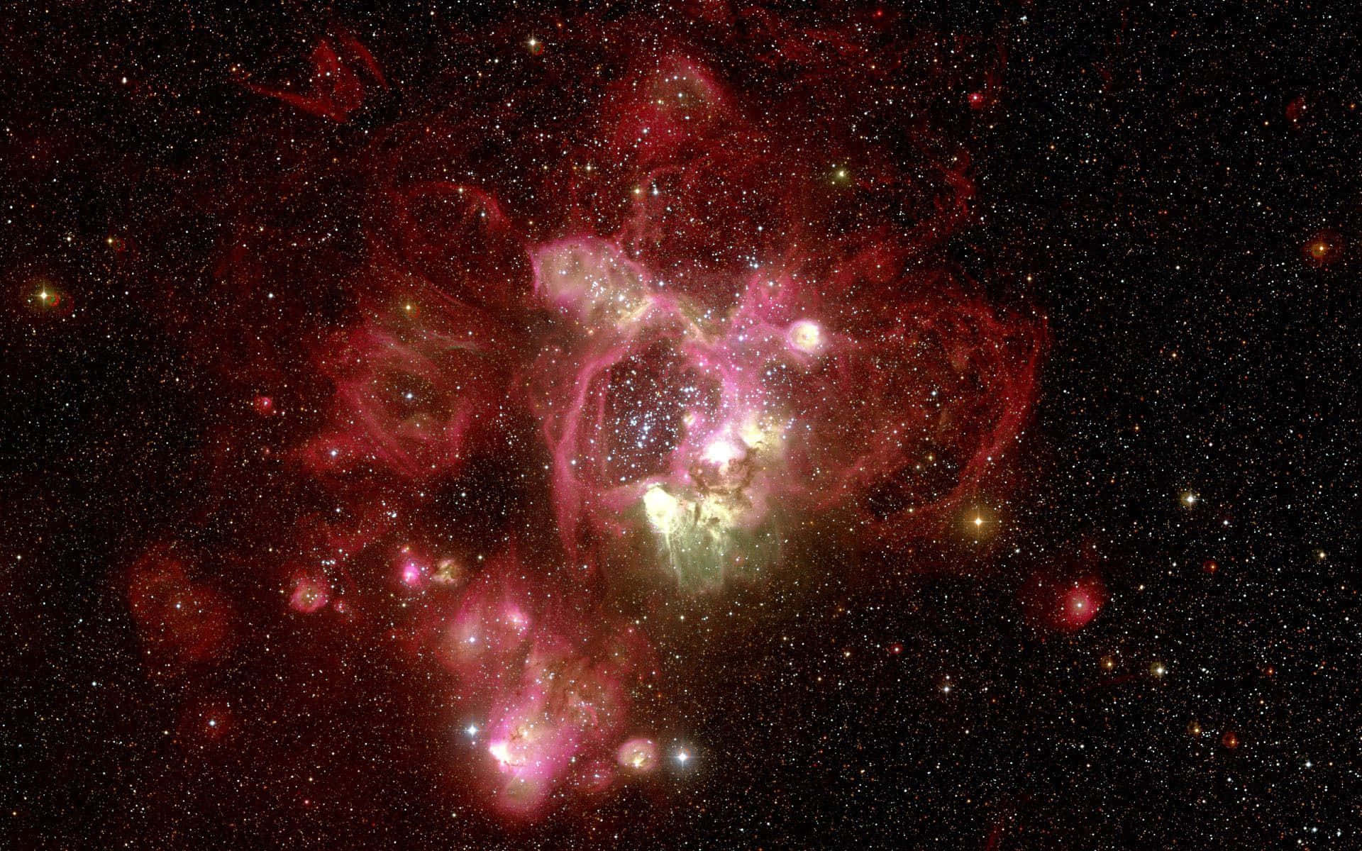 桌布 壁紙 — 一個充滿活力的宇宙星雲，在深空的星場中散發出粉紅色和紅色的雲彩。