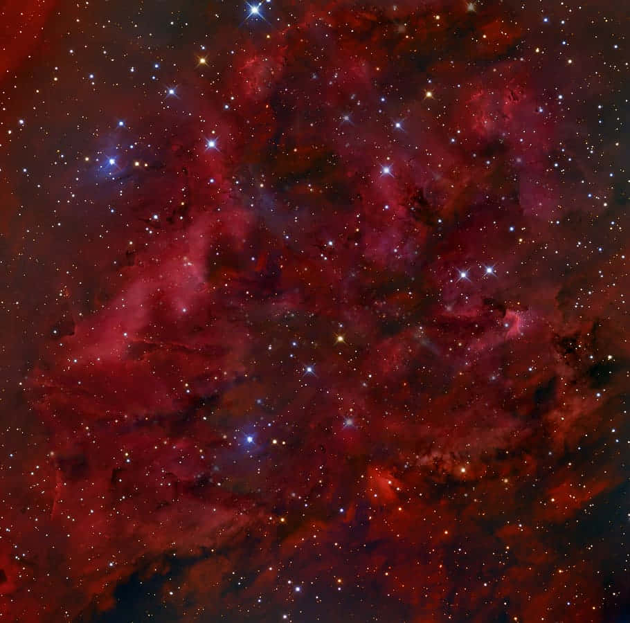 紅色動圖 桌布 壁紙 — 一個充滿活力的宇宙星雲，在深紅色和紫色中發光，黑暗虛空中有散落的明亮星星。