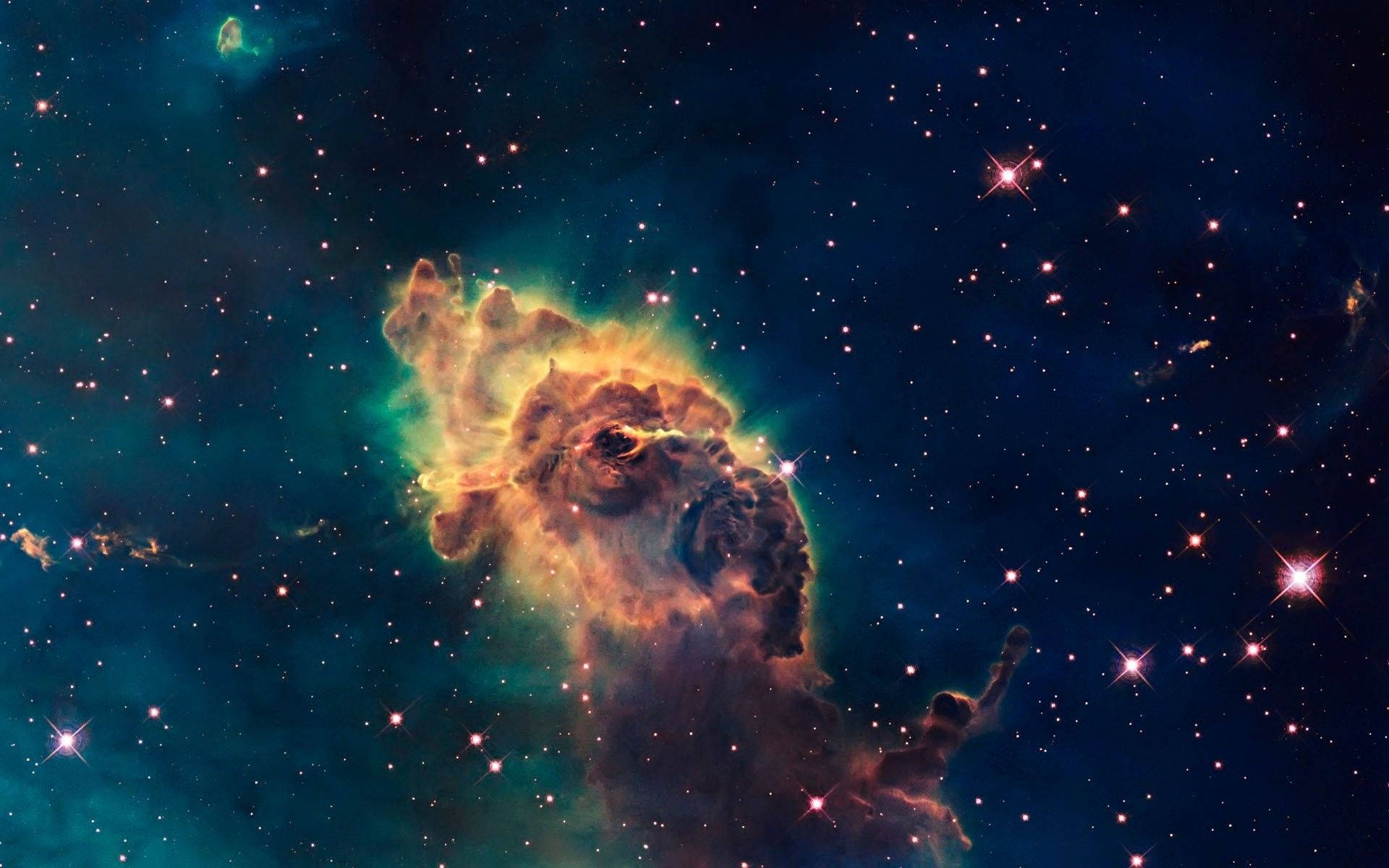 銀河 桌布 壁紙 — 一個充滿活力的宇宙星雲，在閃爍的星空中散發出火熱的橙色和藍綠色調。