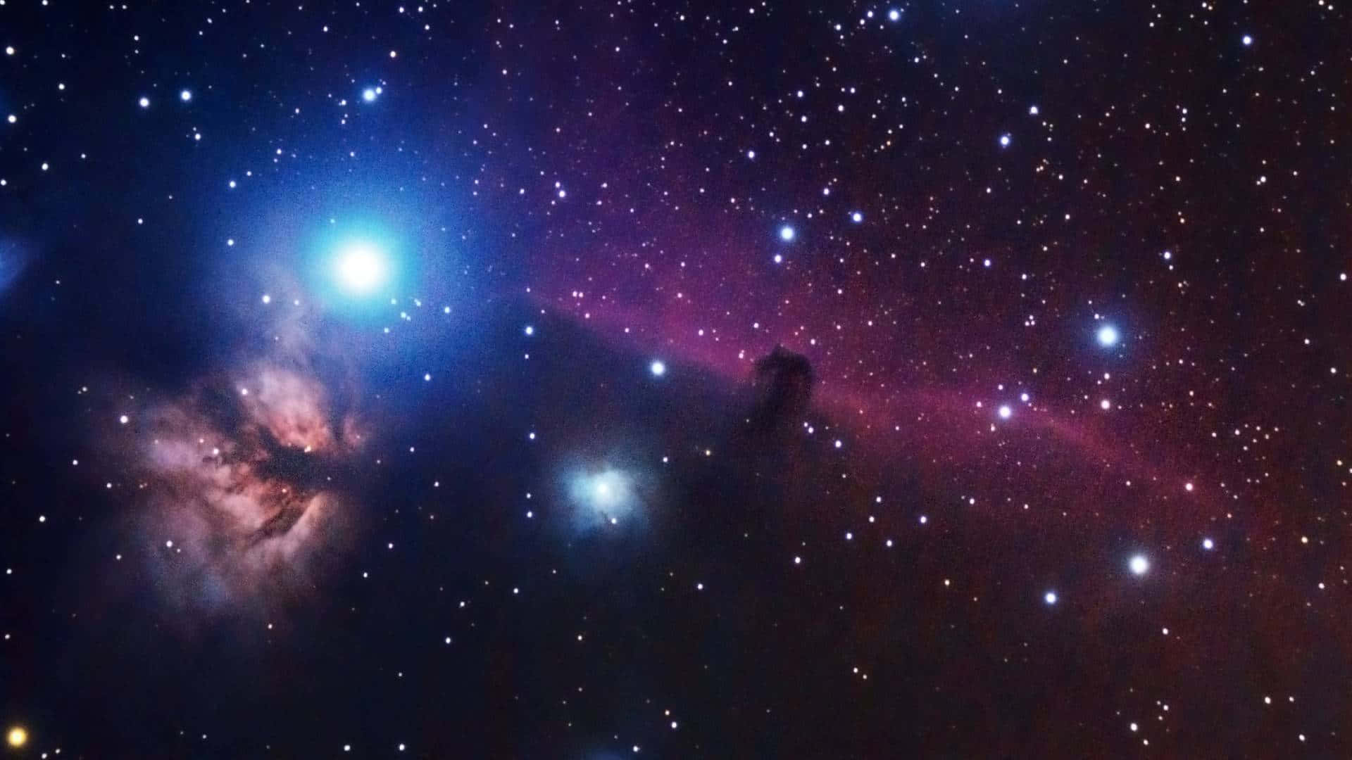 酷炫太空 桌布 壁紙 — 一個充滿活力的宇宙星雲，在黑暗的宇宙天空下，以電光藍和深洋紅色在星場中發光。