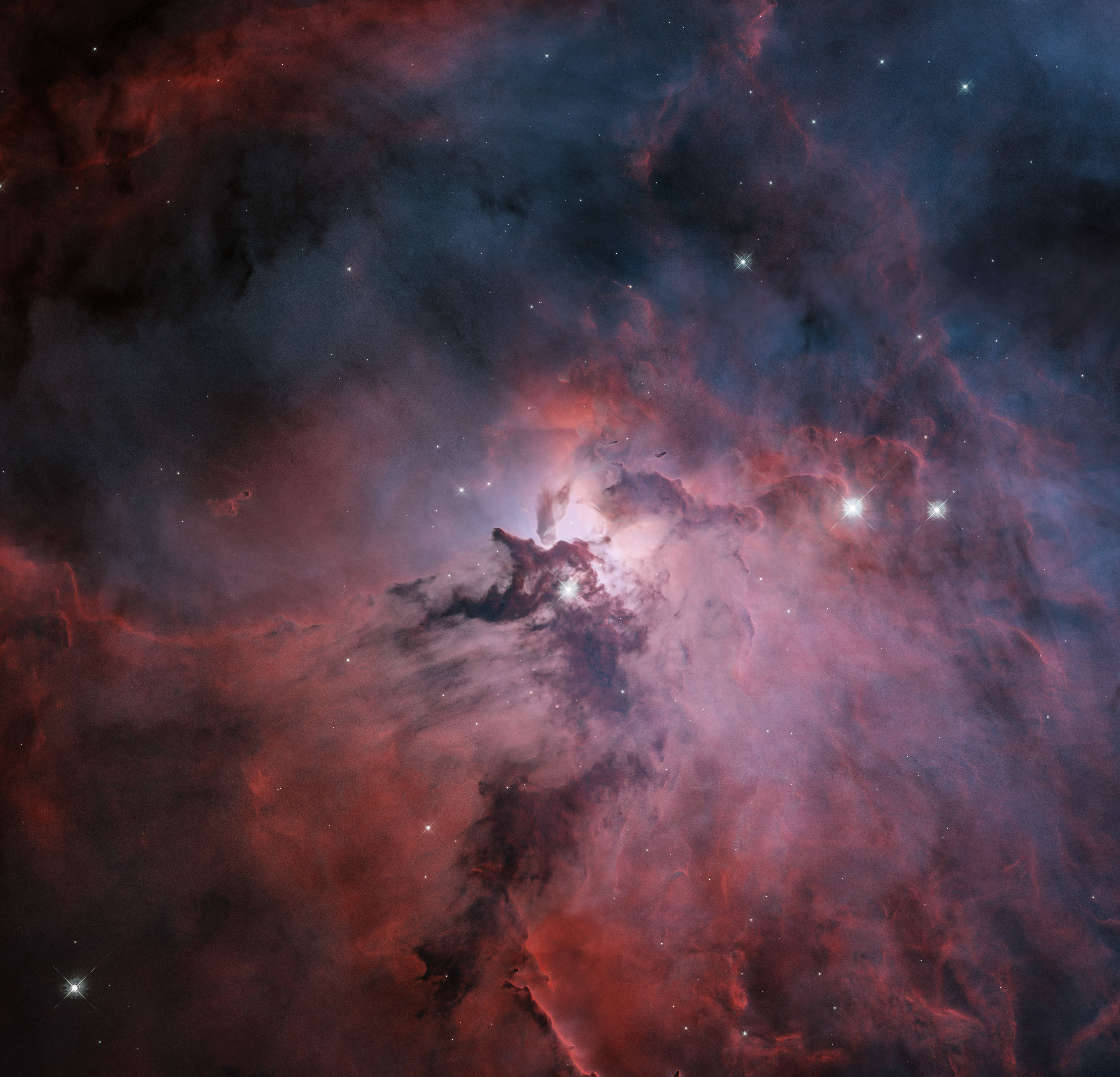 星雲 桌布 壁紙 — 一個充滿活力的宇宙星雲，在黑暗虛空中由明亮恆星照亮的深紅和靛藍色雲層中旋轉。