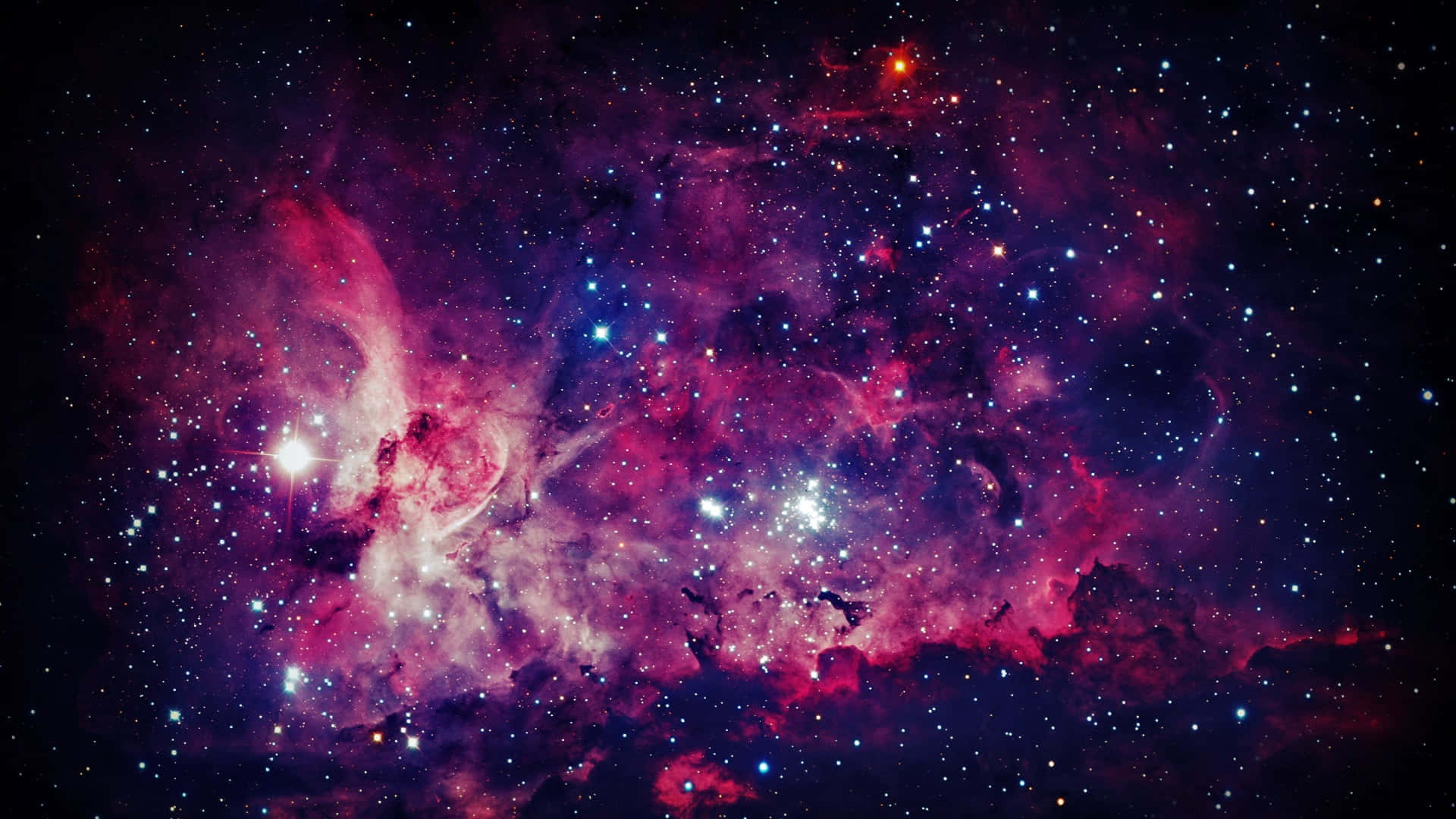 Purple Galaxy 桌布 壁紙 — 一個充滿活力的宇宙星雲，在黑暗虛空中旋轉著粉紅色、紫色和藍色的氣體，由明亮的星星照亮。