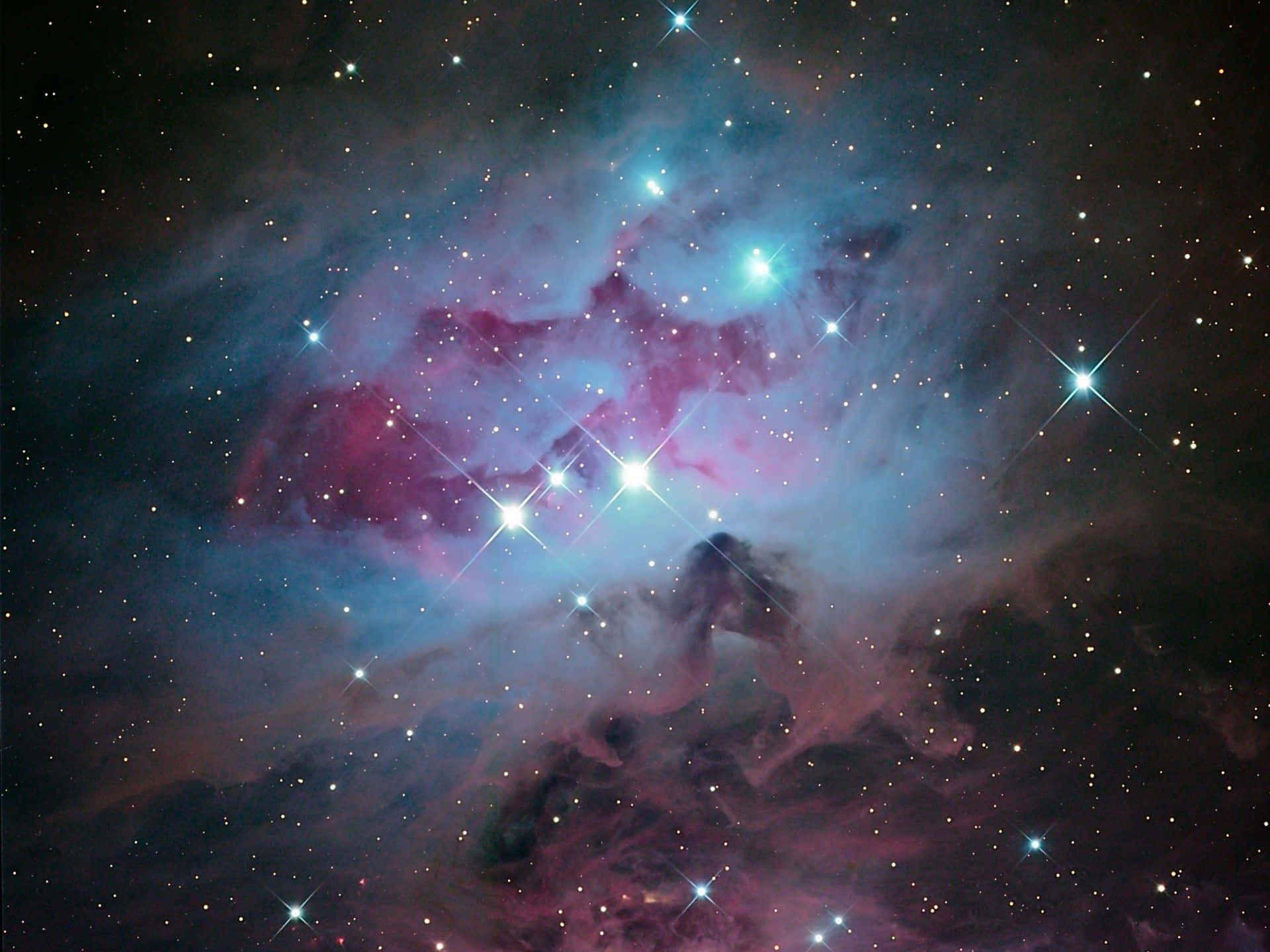 Orion 桌布 壁紙 — 一個充滿活力的宇宙星雲，在黑暗虛空中，由璀璨星辰照亮，散發著粉紅和藍綠色的雲彩。