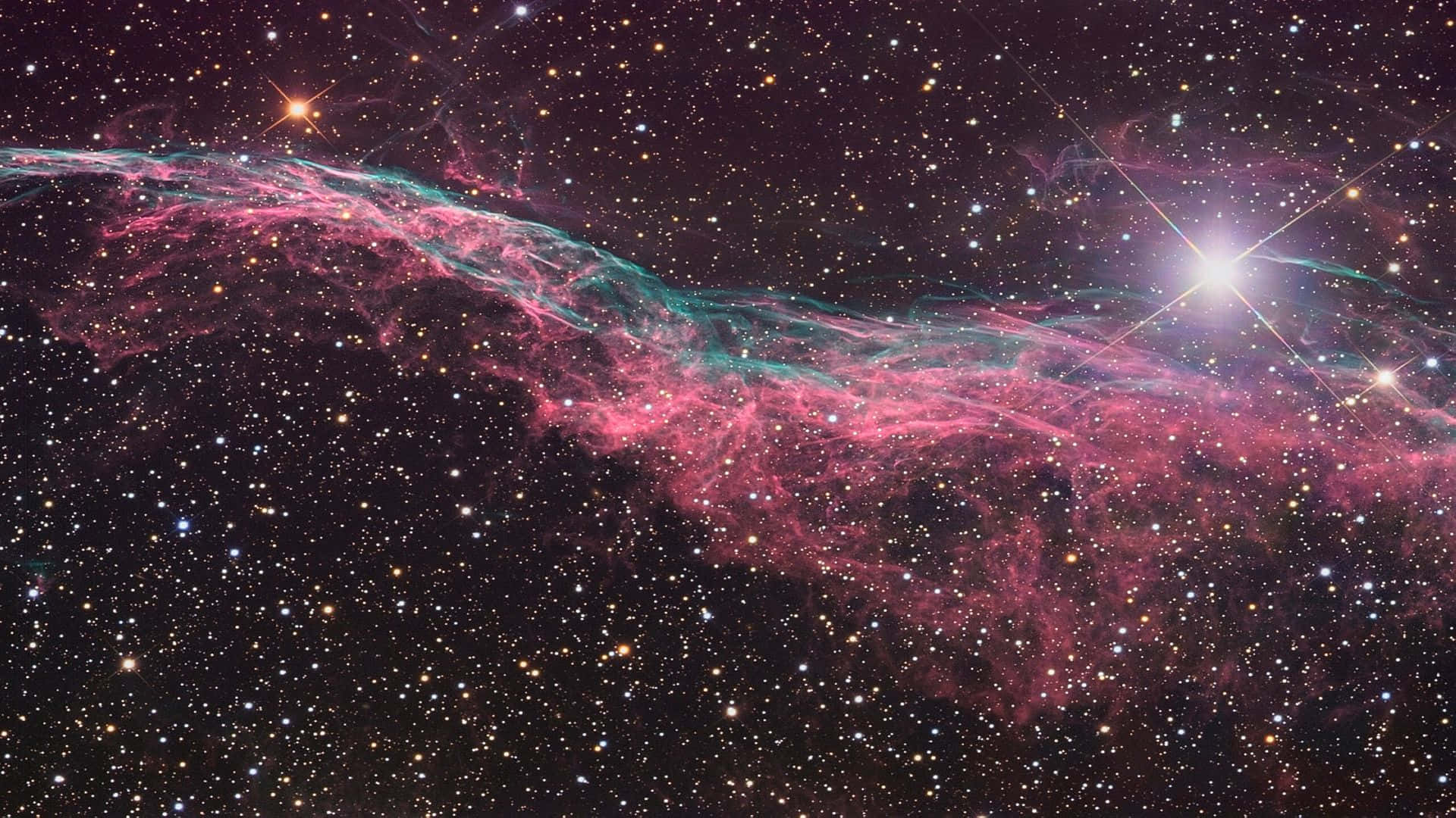 銀河 桌布 壁紙 — 一個充滿活力的宇宙星雲，帶有粉紅色和藍綠色的氣體雲，在黑暗的宇宙天空下延伸穿過星場。
