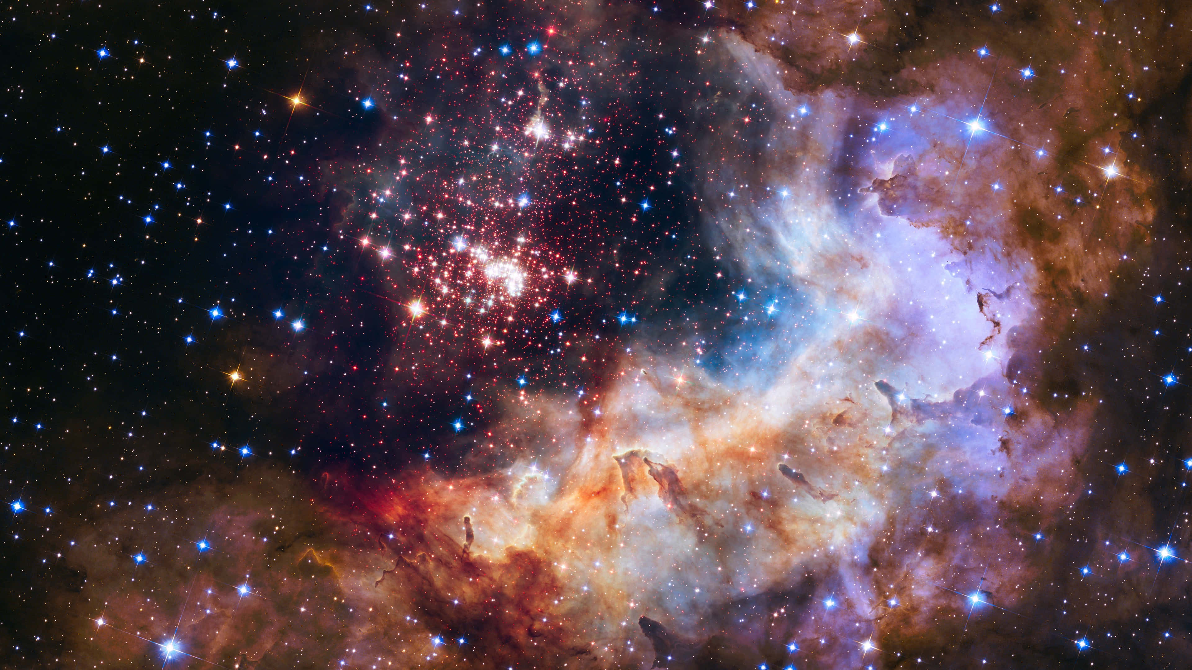 Cosmic Rays 桌布 壁紙 — 一個充滿活力的宇宙星雲，紅色、橙色和藍色的氣體在深邃的黑色虛空中旋轉，被無數閃爍的星星照亮。