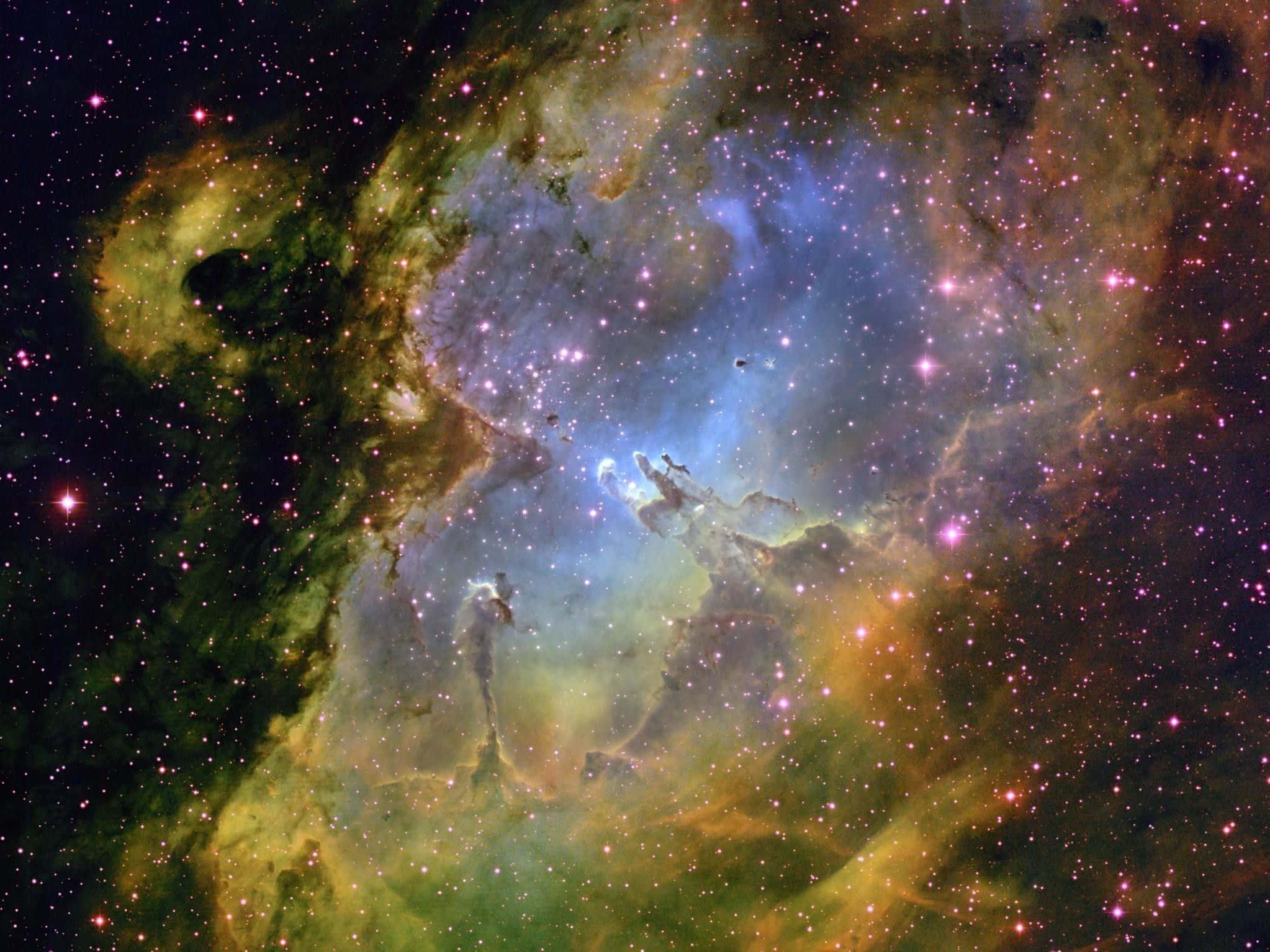 Space Nebula 桌布 壁紙 — 一個充滿活力的宇宙星雲，藍色、綠色和橙色的氣體雲團旋轉，點綴著閃爍的星星，背景是黑暗的虛空。