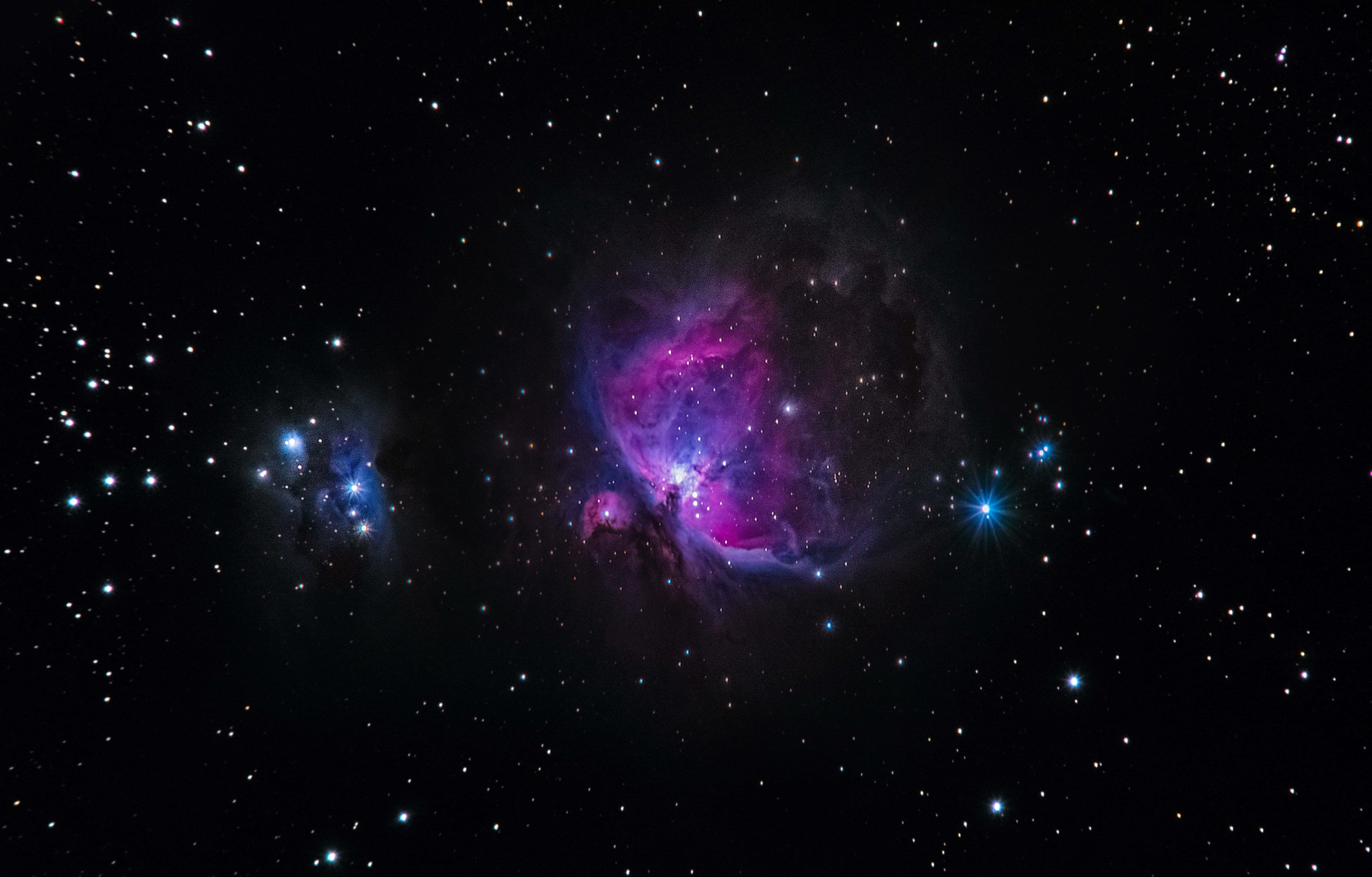 桌布 壁紙 — 一個充滿活力的宇宙星雲在深空的星場中散發出洋紅色和藍色的光芒。