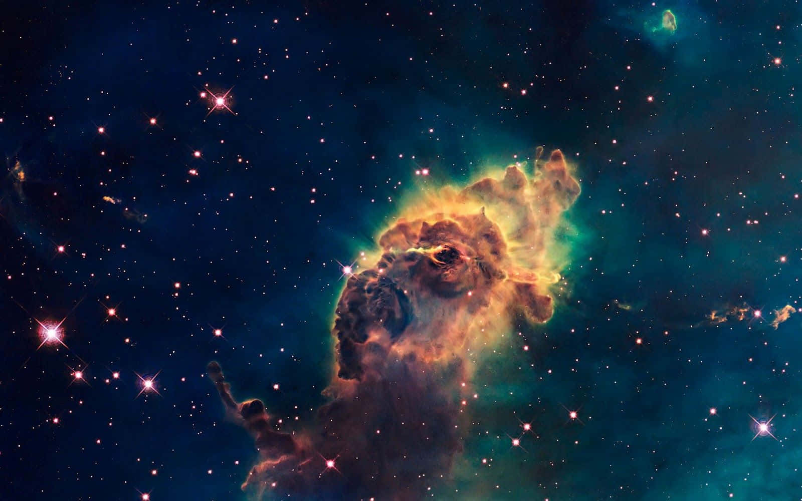 酷炫太空 桌布 壁紙 — 一個充滿活力的宇宙星雲在深空的星場中散發出橙色和藍綠色的光芒。