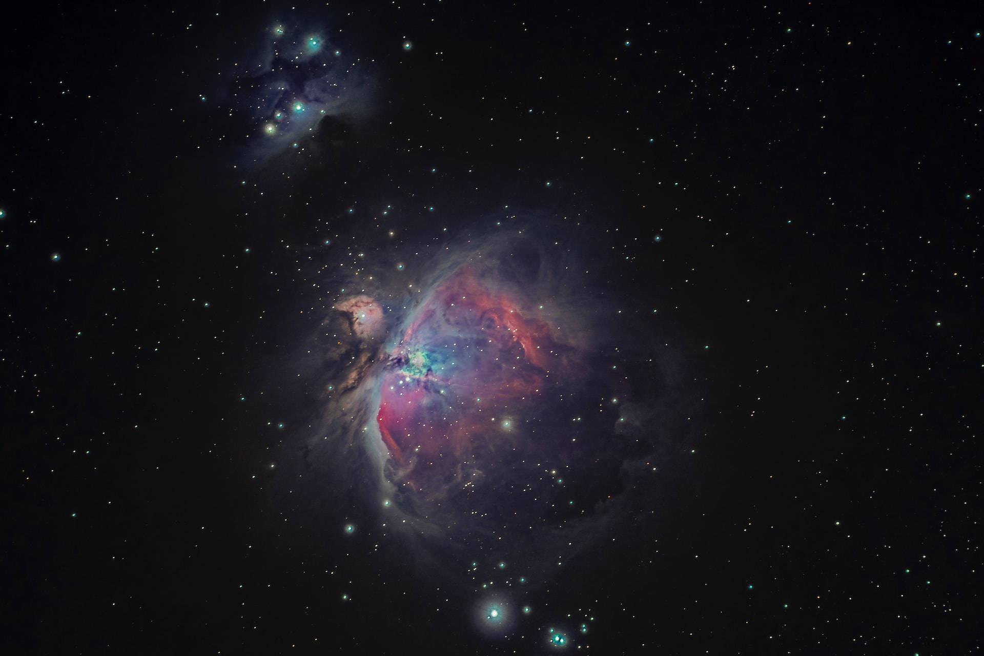 Stars 桌布 壁紙 — 一個充滿活力的宇宙星雲在深空的星場中散發出紅色、紫色和藍色的光芒。