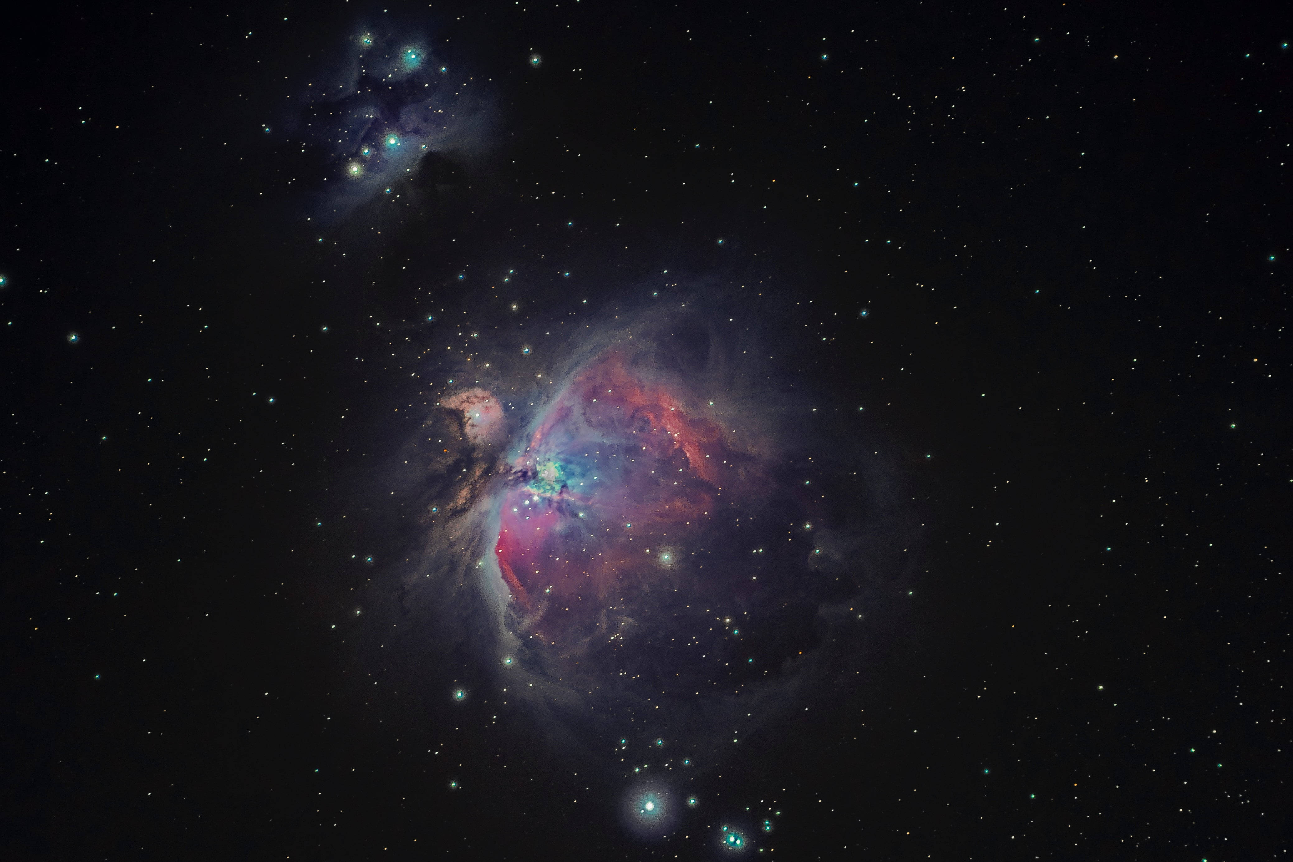 太空 桌布 壁紙 — 一個充滿活力的宇宙星雲在深空的星場中散發出紅色、紫色和藍色的光芒。