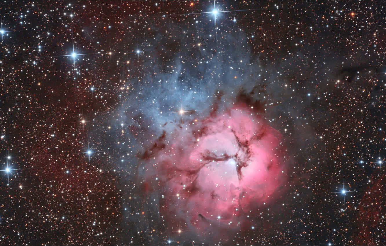 Beautiful Star 桌布 壁紙 — 一個充滿活力的宇宙星雲在深邃太空中閃爍的星群中發出粉紅色和藍色的光芒。