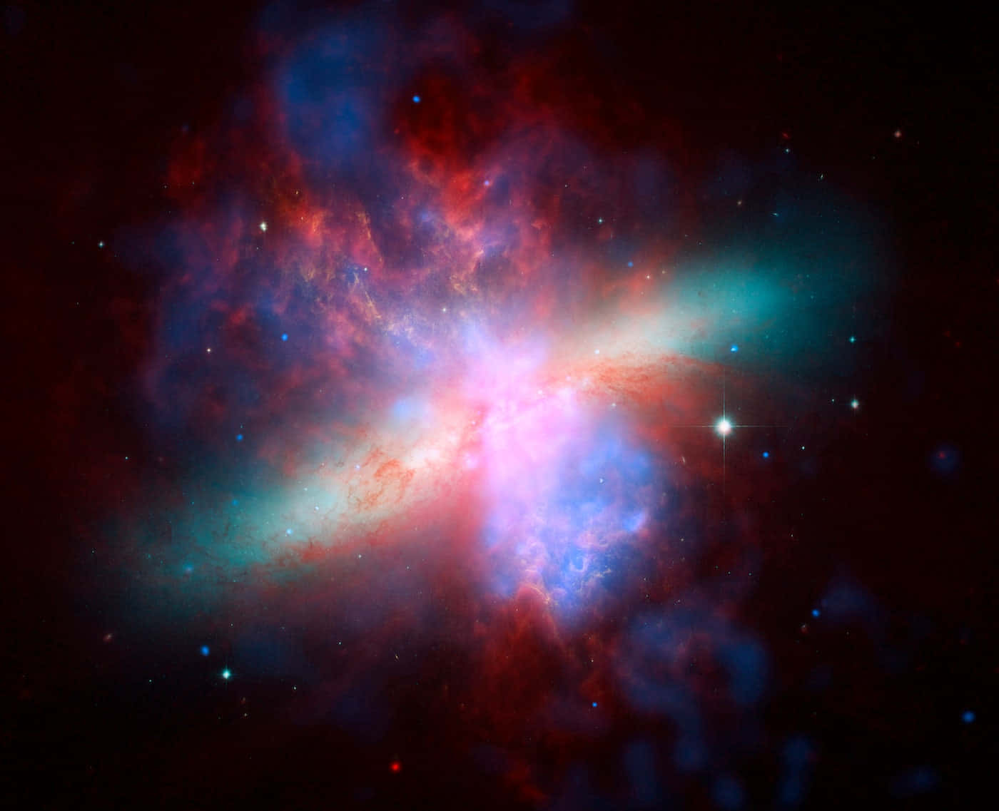 太空 桌布 壁紙 — 一個充滿活力的宇宙星雲在黑暗虛空中旋轉，紅色、藍色和藍綠色氣體被明亮的星星照亮。