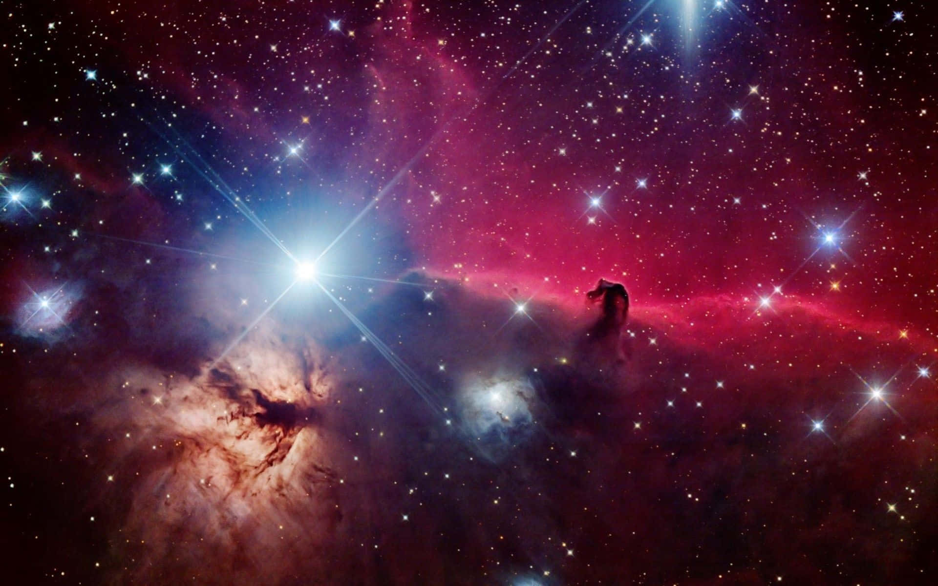 Space Nebula 桌布 壁紙 — 一個充滿活力的宇宙星雲散發著紅色、紫色和藍色的光芒，璀璨的恆星穿透旋轉的宇宙塵埃。