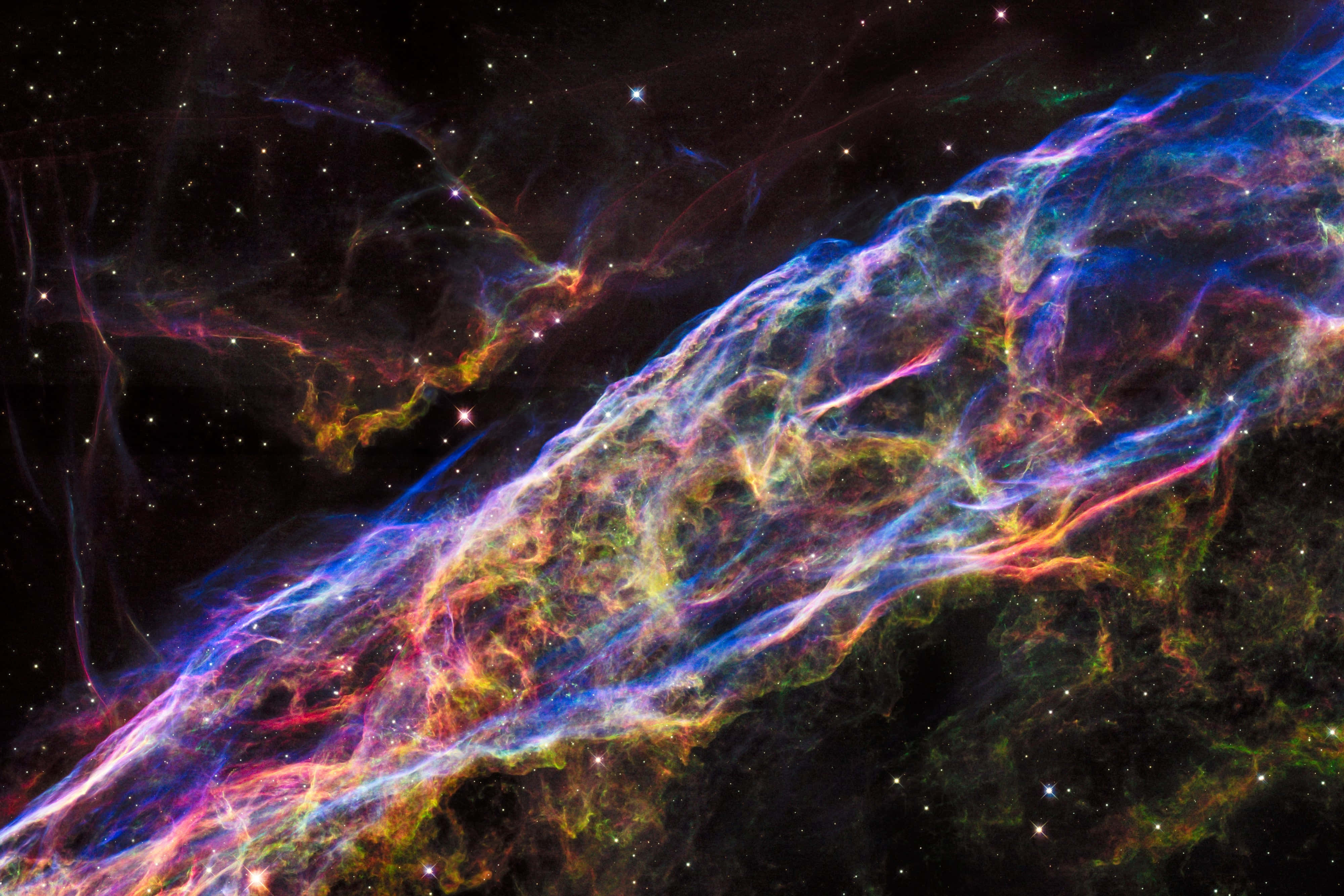 Bifrost 桌布 壁紙 — 一個充滿活力的宇宙星雲橫跨佈滿星星的虛空，帶有發光的藍色、紫色和橙色絲狀物。