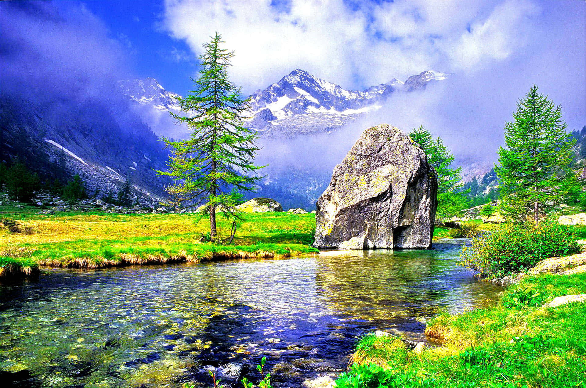 Beautiful Artistic 桌布 壁紙 — 一個充滿活力的山谷，清澈的溪流流過一塊大石頭和常青樹，天空多雲而戲劇化。