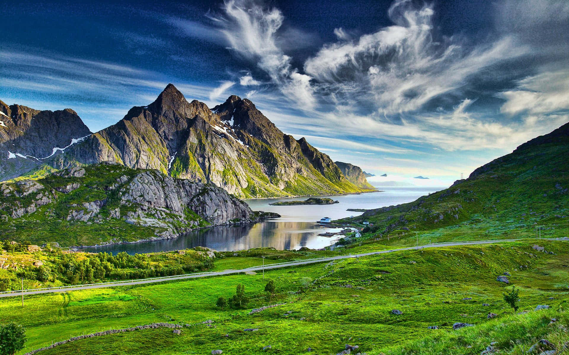 Green Landscape 桌布 壁紙 — 一個充滿活力的峽灣，坐落於高聳的綠色山脈之間，上方是戲劇性的藍天和縷縷白雲。