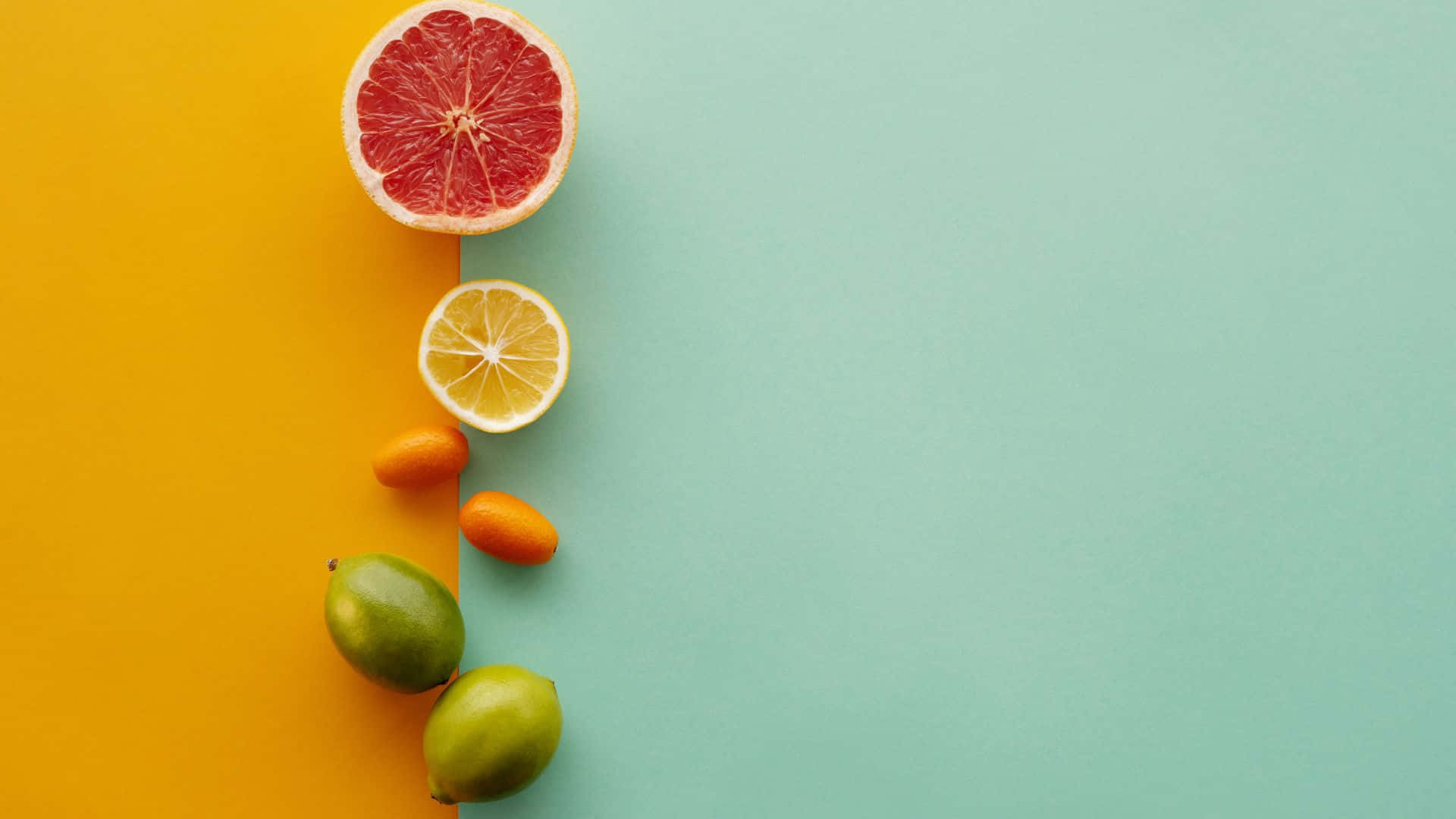 Fruits And Vegetables 桌布 壁紙 — 一個充滿活力的平鋪佈局，將切片和完整的柑橘類水果對角線排列在鮮明的黃色和藍綠色背景上。