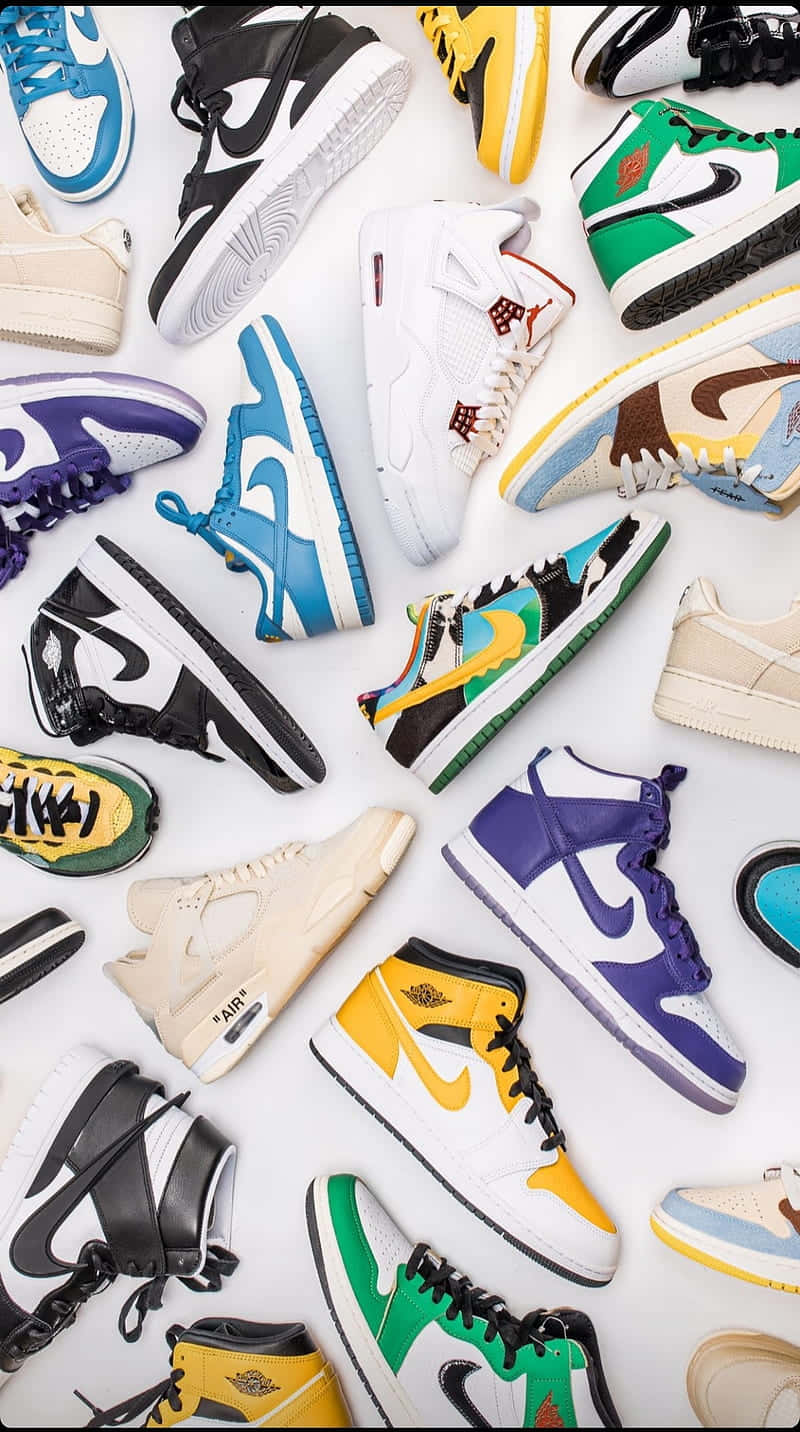 Sneaker 桌布 壁紙 — 一個充滿活力的平鋪圖，各種色彩繽紛的運動鞋整齊排列在潔白的背景上，展示大膽的設計和標誌性品牌。