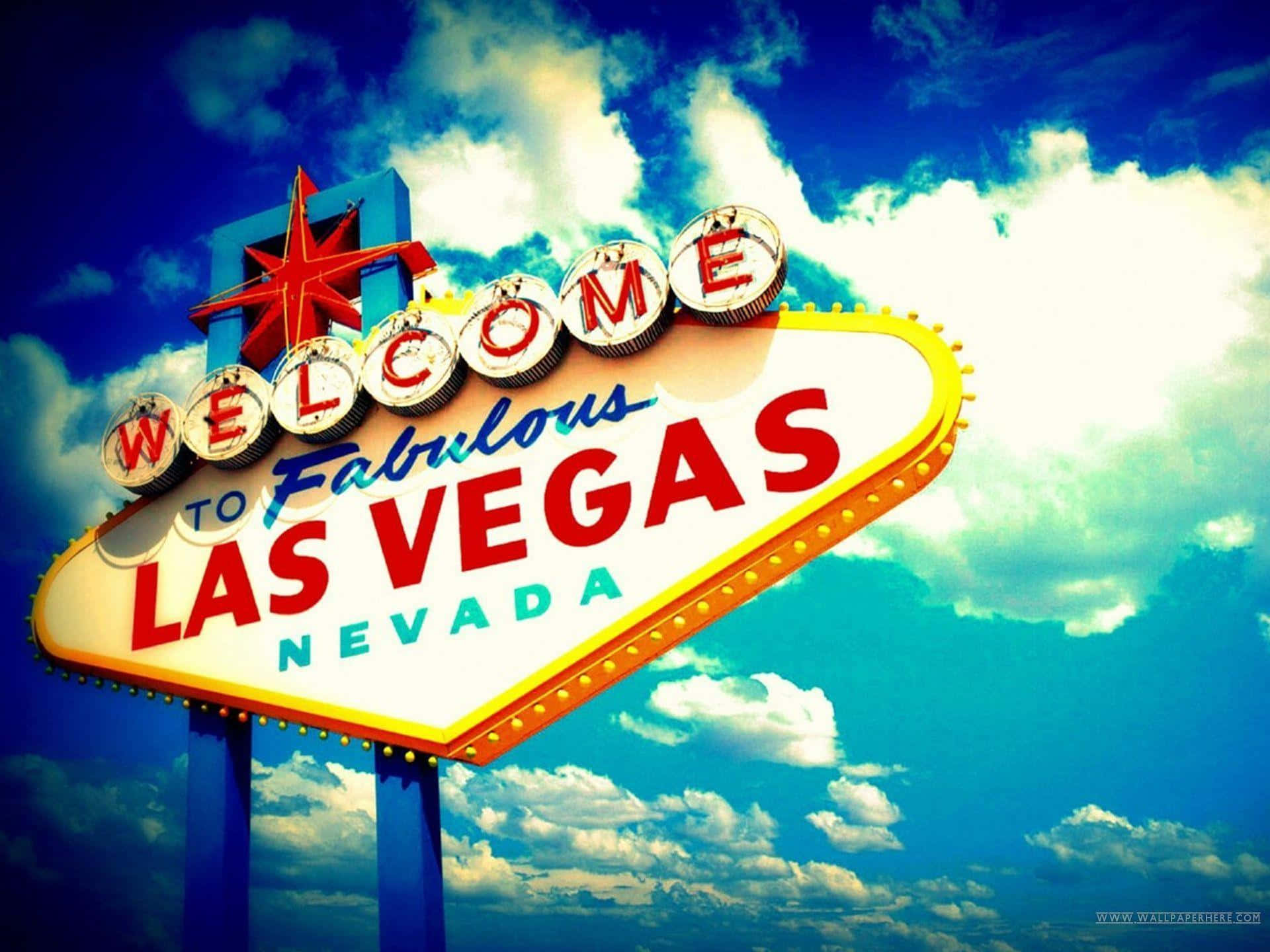 拉斯維加斯 桌布 壁紙 — 一個充滿活力的復古「Welcome to Fabulous Las Vegas Nevada」標誌在晴朗的藍天和 fluffy 白雲下閃耀。