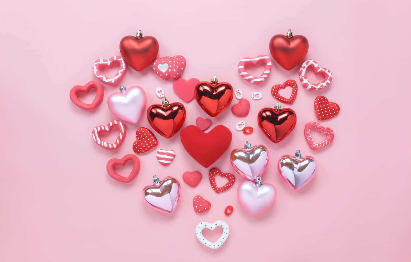 Pink Love 桌布 壁紙 — 一個充滿活力的心形排列，由各種紅色和粉紅色心形組成，帶有閃亮金屬和圖案質感，置於柔和的粉紅色背景上。