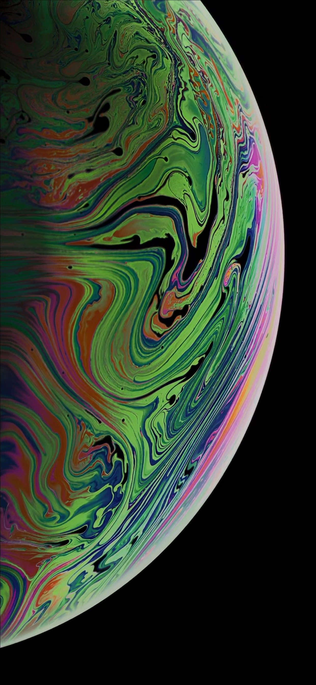 可愛 iPhone 桌布 桌布 壁紙 — 一個充滿活力的旋轉肥皂泡，在黑色背景上呈現出虹彩般的綠色、橙色和紫色色調。