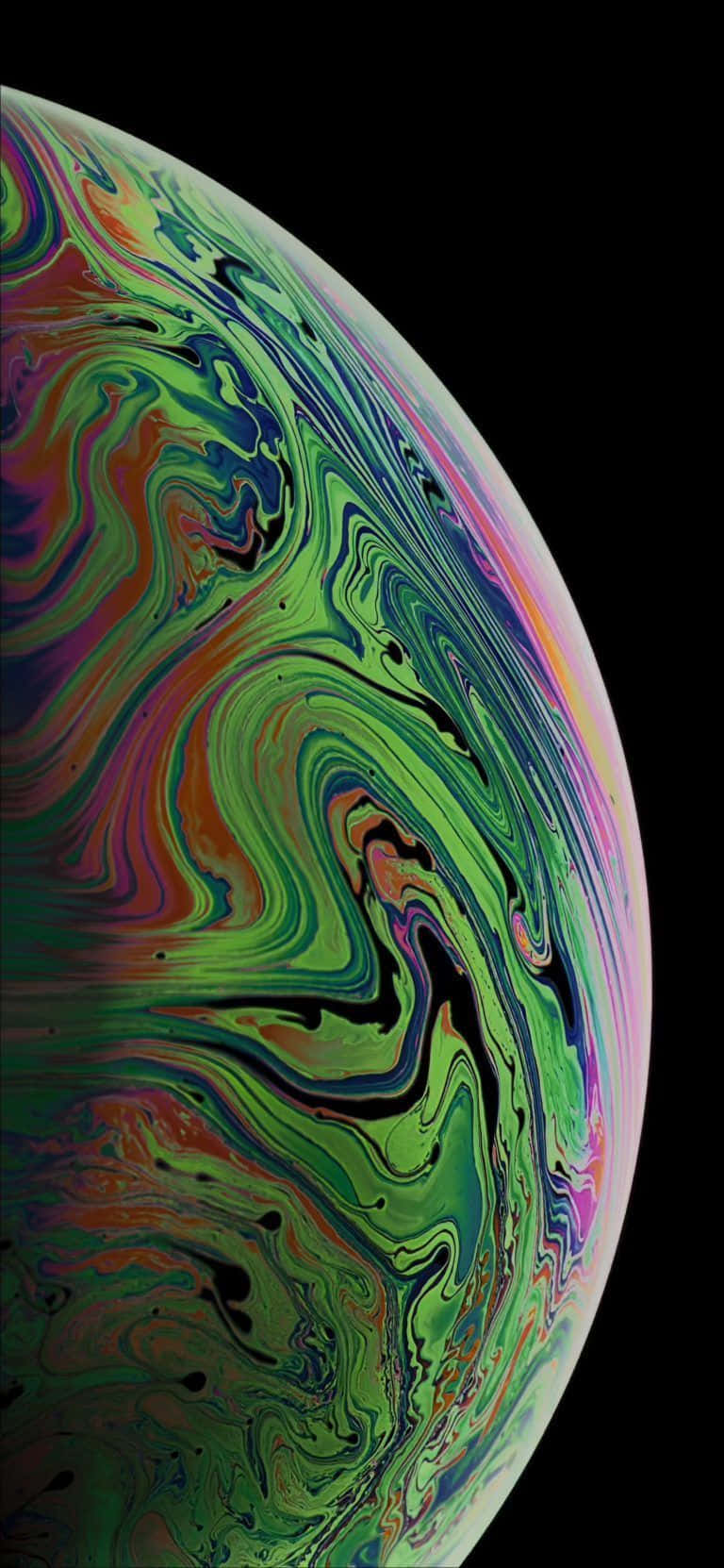 Apple iPhone Xs 桌布 壁紙 — 一個充滿活力的旋轉肥皂泡，帶有虹彩的綠色、紫色和粉紅色，映襯在純黑色背景上。