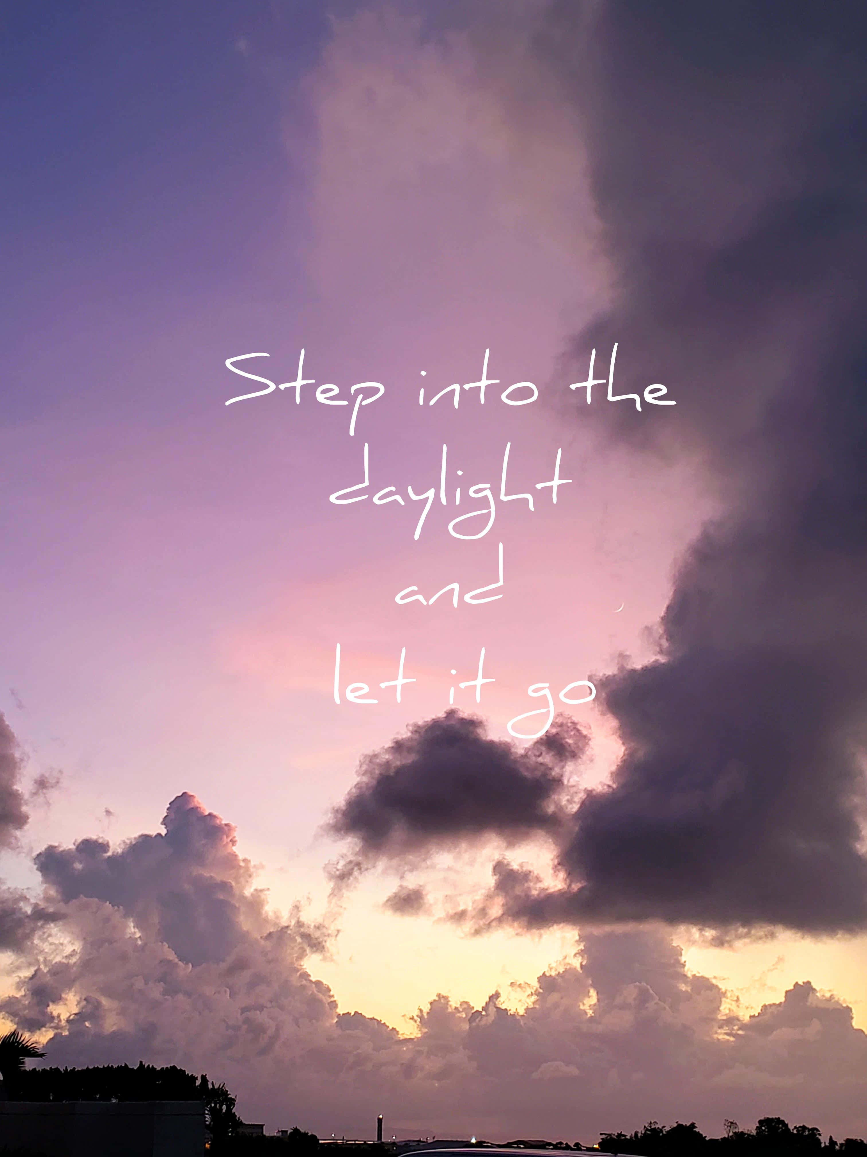 let it go 桌布 壁紙 — 一個充滿活力的日落天空，帶有紫色和金色的雲彩，在遙遠的地平線上方有手寫文字「Step into the daylight and let it go」。